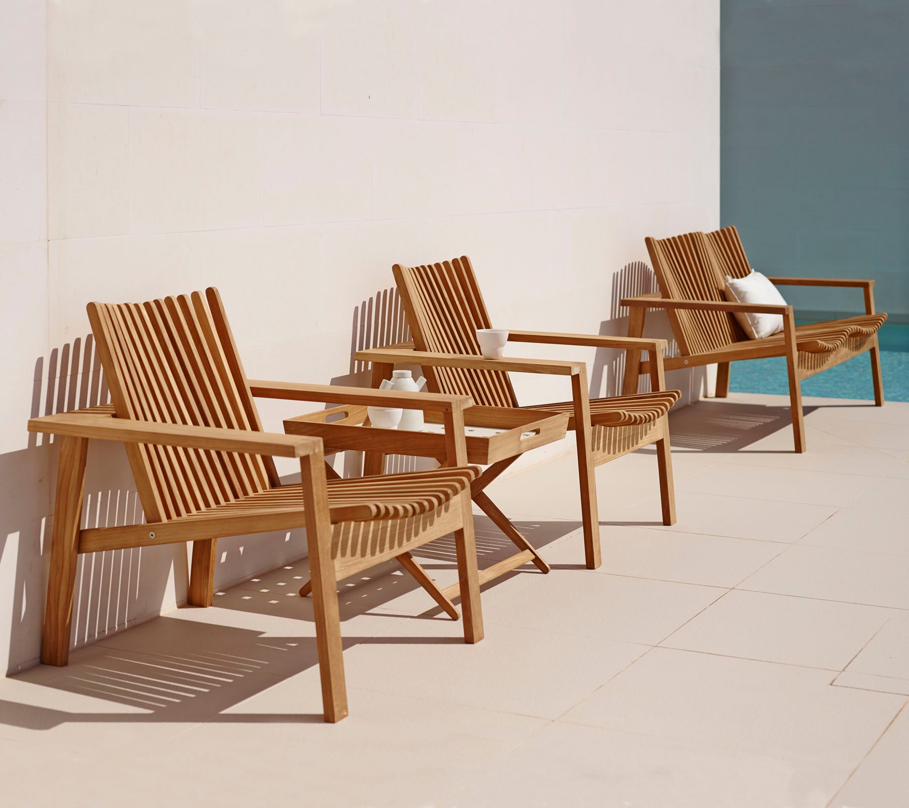 Tre træ loungestole med brædder designet i en række, med en enkel, elegant stil velegnet til afslapning.