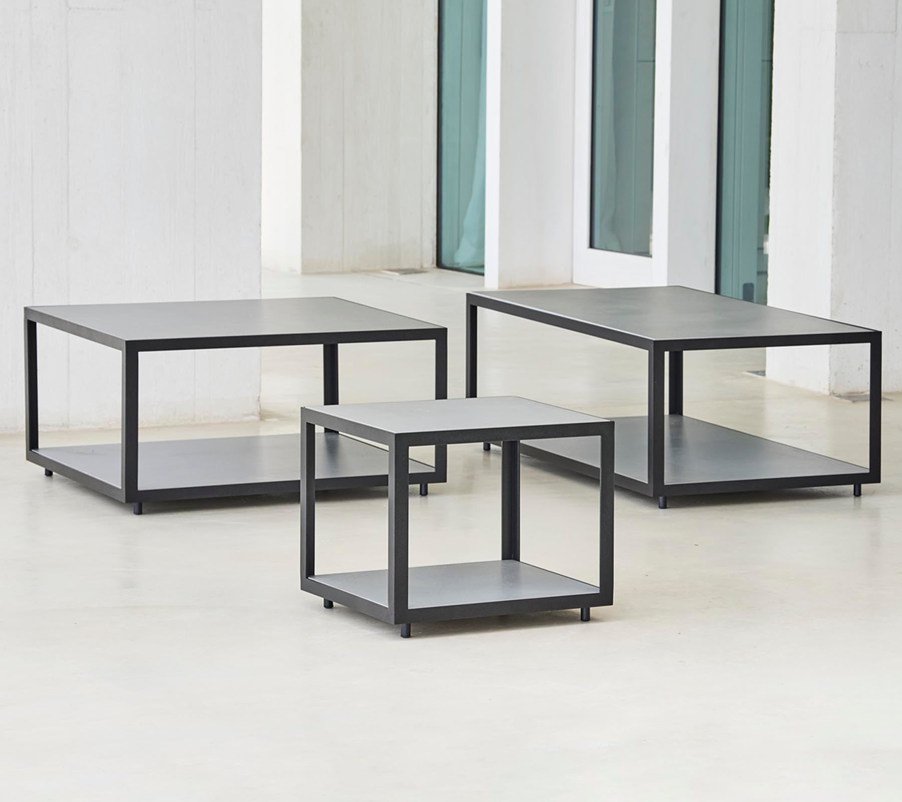 Tre moderne borde med et minimalistisk design, der har en slank ramme og flere niveauer til opbevaring eller visning.