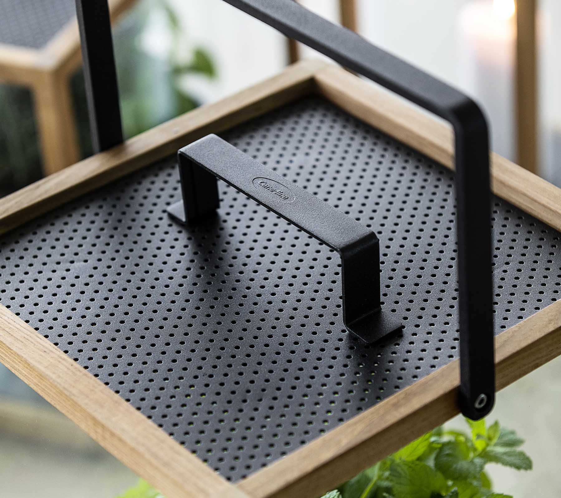 Dekorativ bakke med en struktureret sort overflade og et robust håndtag, perfekt til at vise planter eller servere varer.