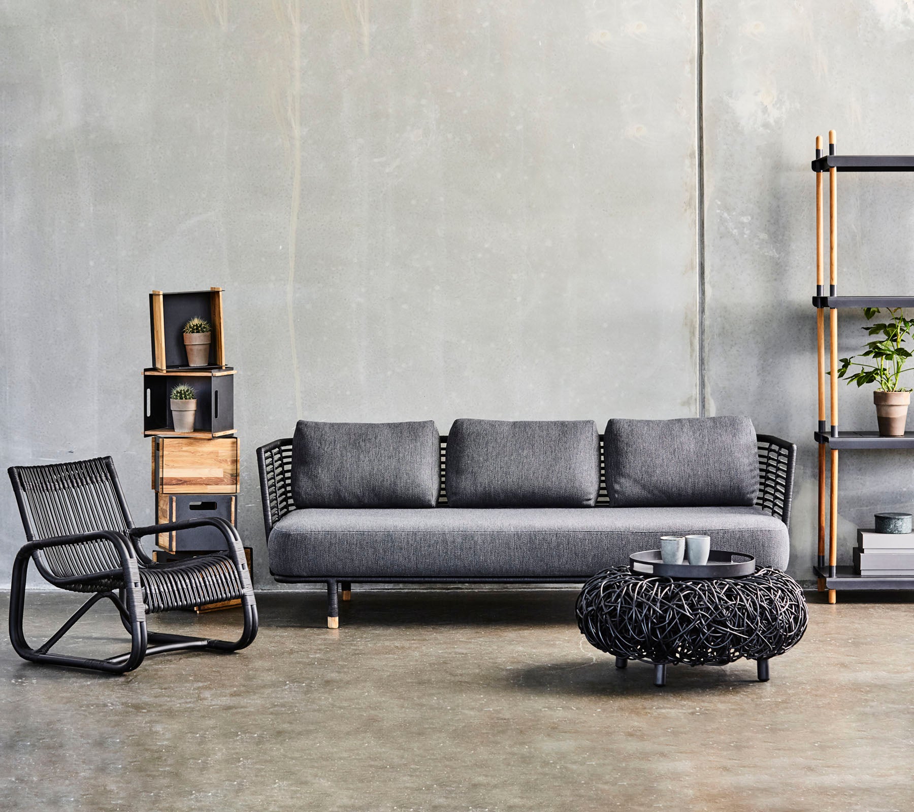 Moderne stueopsætning med en strømlinet sofa, et tekstureret kaffebord og en stilfuld accentstol, suppleret med dekorative hylder.