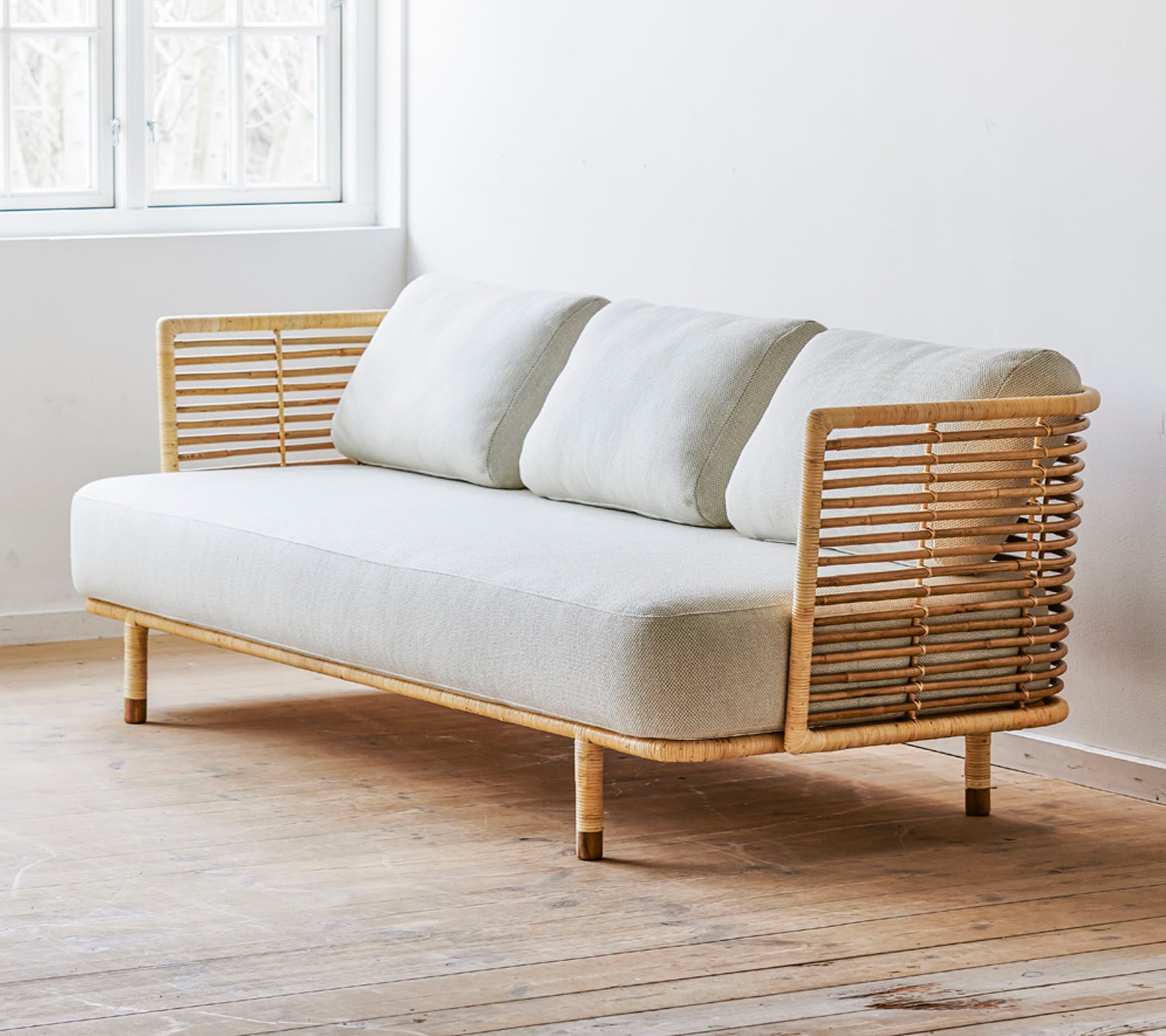 En moderne sofa med et slankt design, der har et lyst stofsæde og stilfulde trædetaljer. Perfekt til moderne rum.