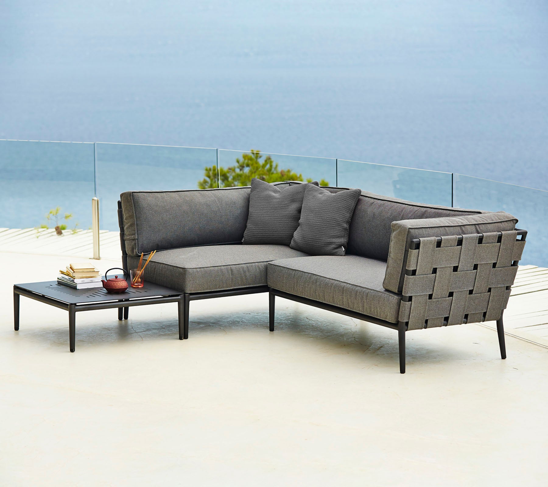 Stilfuld udendørs sofa i sektioner med komfortable puder og et matchende sidebord, perfekt til afslapning og fornøjelse.