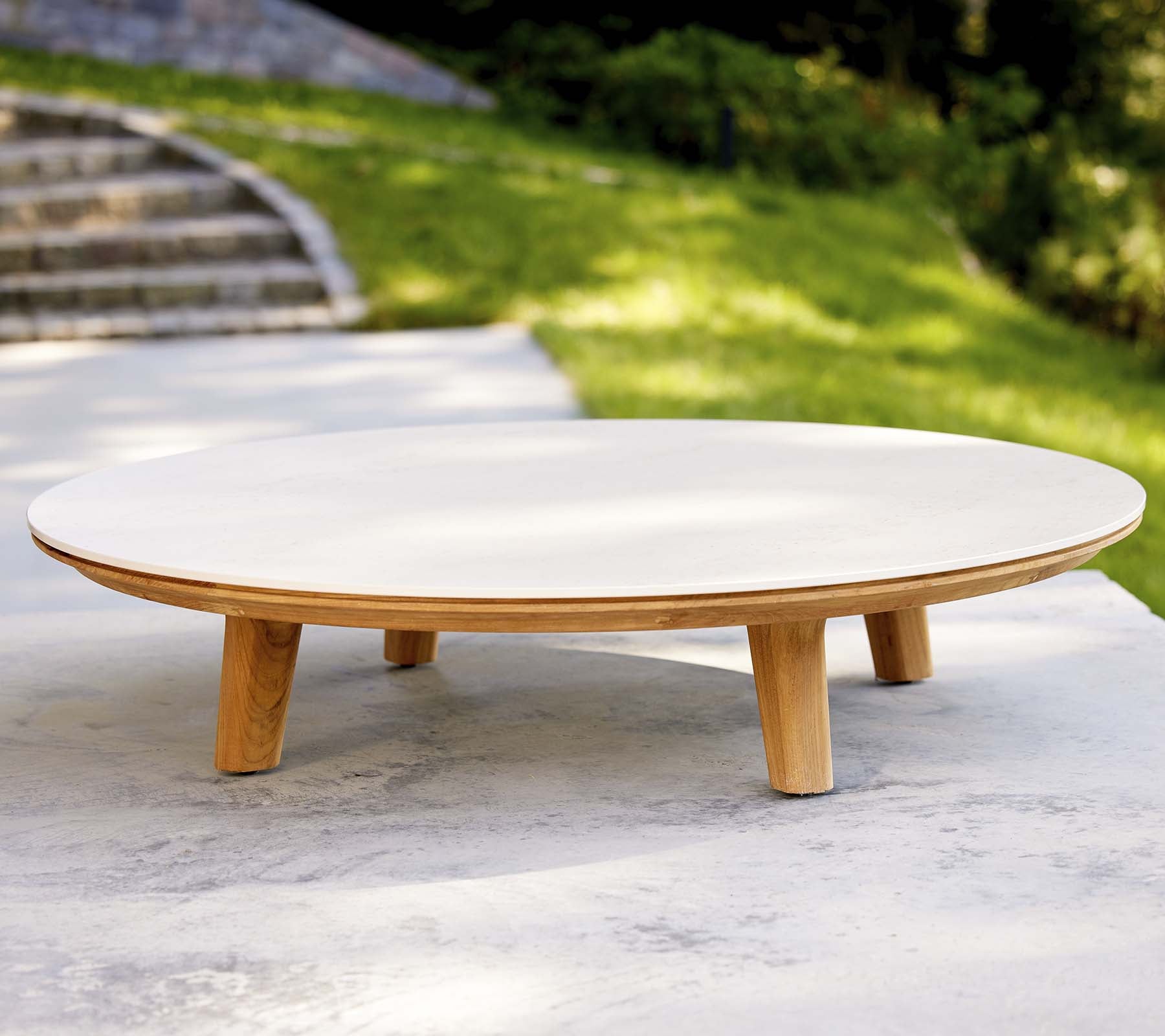 Modernt rundt kaffebord med en glat overflade og træben, med et minimalistisk design der passer til forskellige omgivelser.