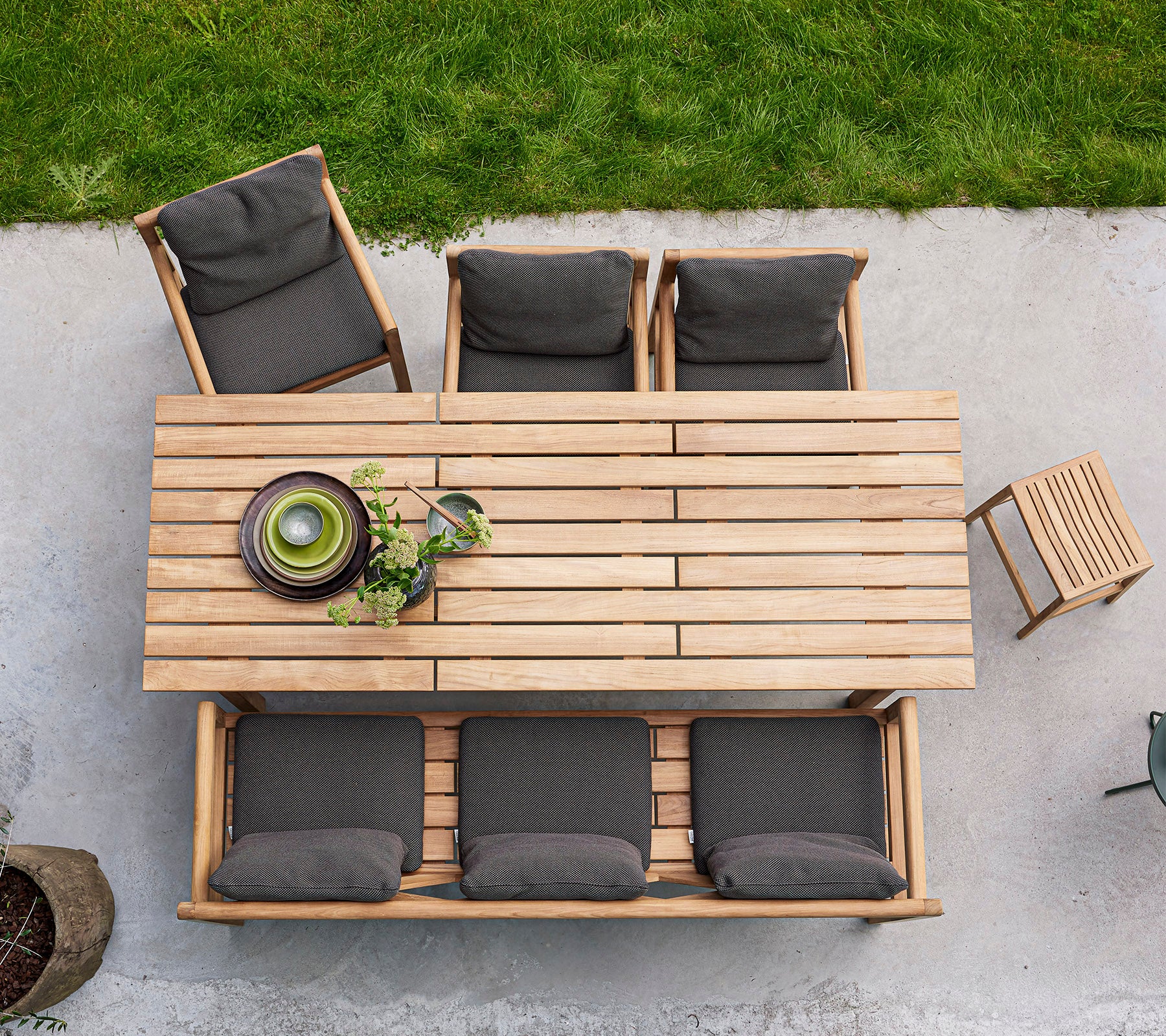 Et træ spisebord med fire polstrede stole og en skål med grønne planter, arrangeret til en indbydende sammenkomst.