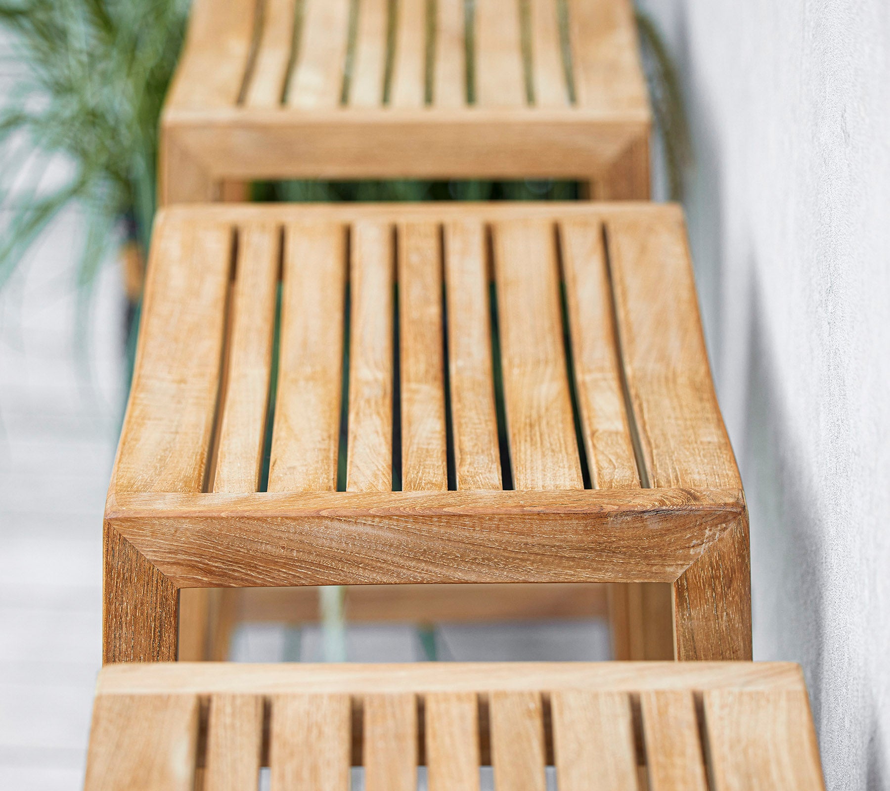Træbænke med spalte-design arrangeret i en række med et minimalistisk udtryk, der fremhæver naturlige strukturer og finish. Velegnet til forskellige miljøer.
