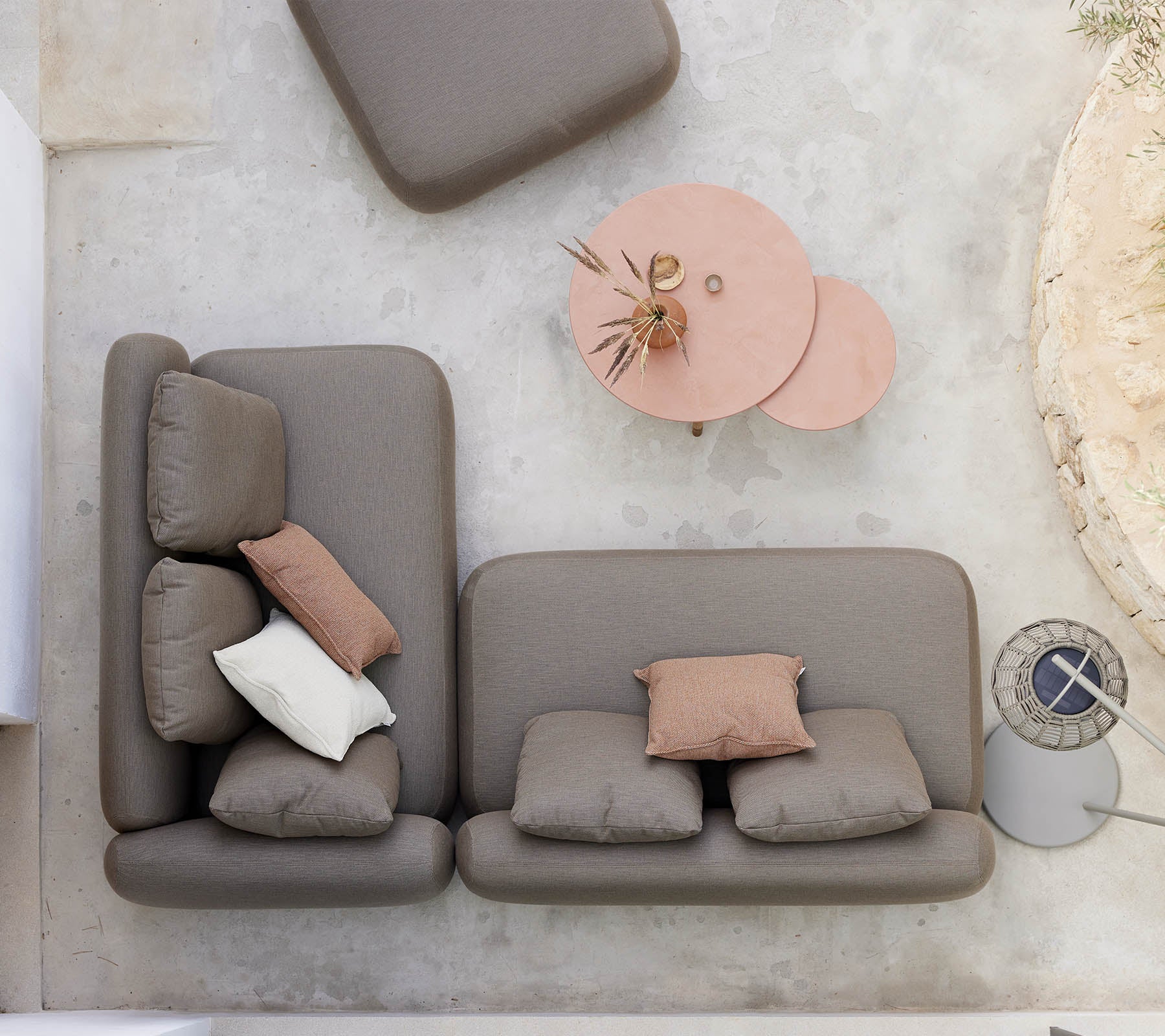 Et stilfuldt siddearrangement med en sofa i neutrale farver med dekorative puder, ledsaget af et unikt twist-kaffebord.