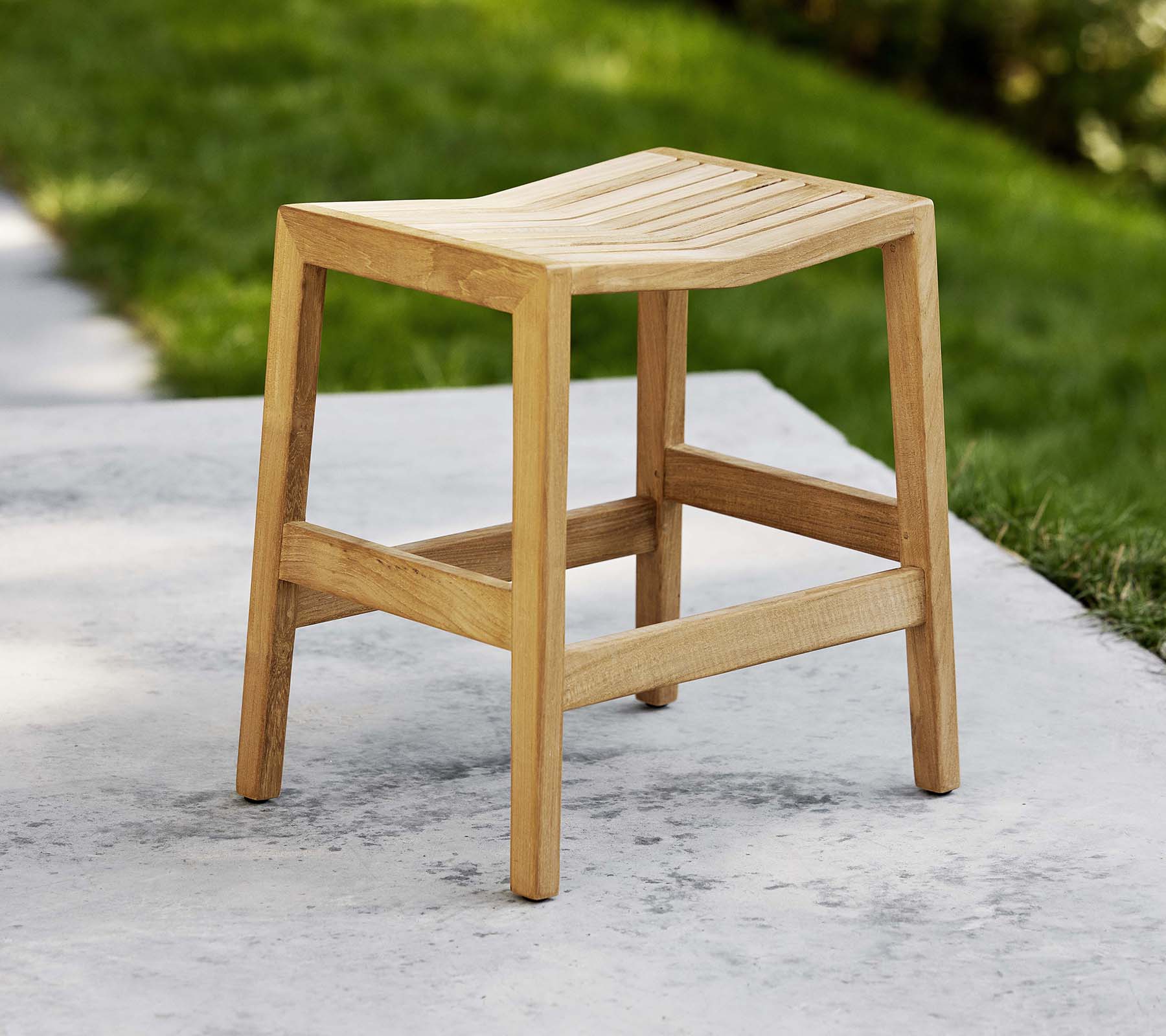 En træflipstol med en lamel sæde og sturdy ben, designet til alsidig brug som sæde eller pynt.