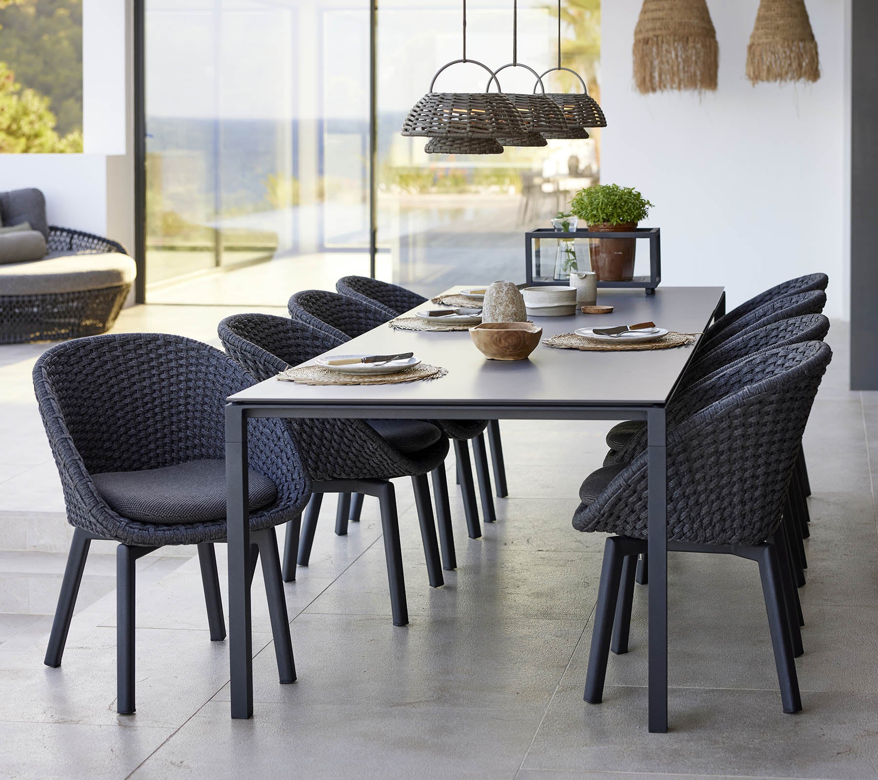 Et stilfuldt spise setup med et rent spisebord, påfuglestole og en illusionslampe, der forbedrer en moderne æstetik.