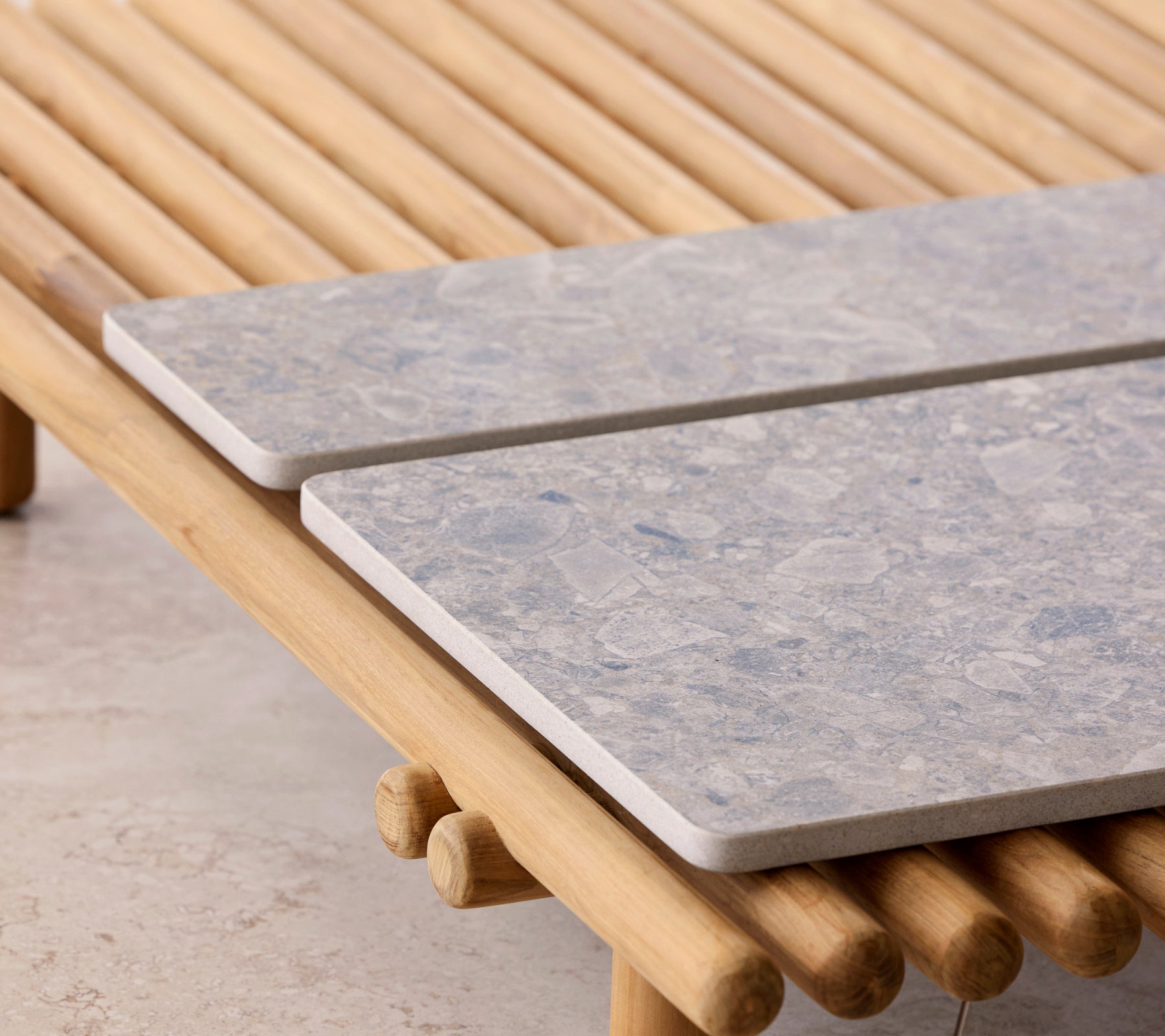 Et sofabord med et stangdesign og to steinplader som bordplader.