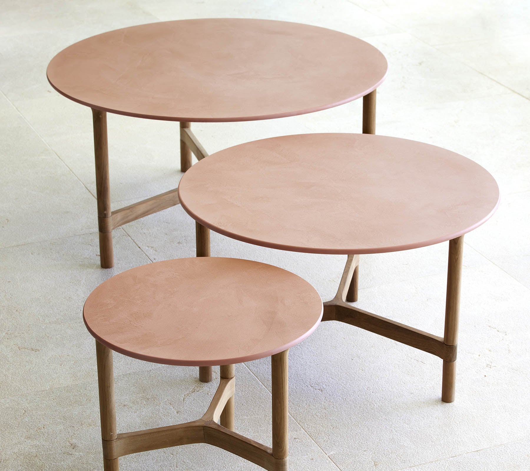 Tre runde sofaborde i forskellige størrelser med et minimalistisk design med træben og en glat, elegant overflade.
