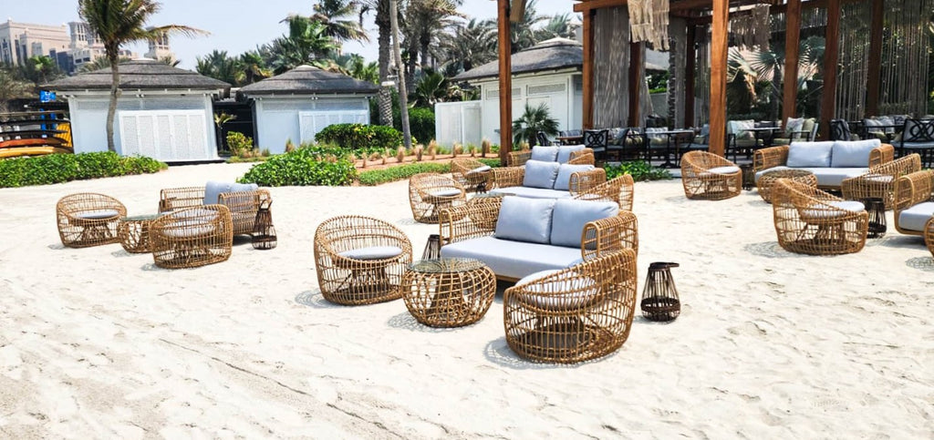Strand med flere sæt af flettede lounge møbler i naturfarve, 