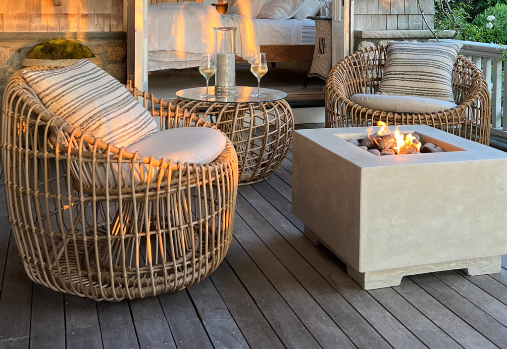 Udendørs skulpturelle loungestole i naturfarve med teaktræs sidebord, møbleret på en veranda