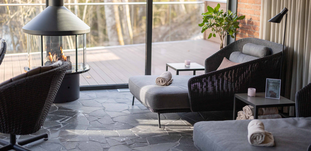 Cane-line loungemøbler ved Hestraviken Riverside spa loungeområde. Her ses Mega sort daybed og Peacock grå lounge drejestol 