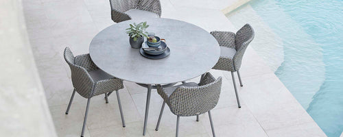 A round dining table surrounded by four stylish chairs, complemented by a decorative centerpiece. Ideal for gatherings and relaxation.