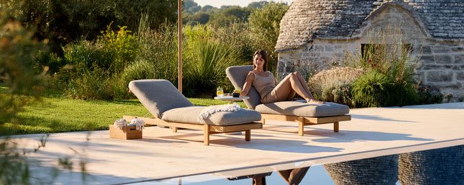 Nutidige grå loungestole ved en pool i en udendørs indstilling.