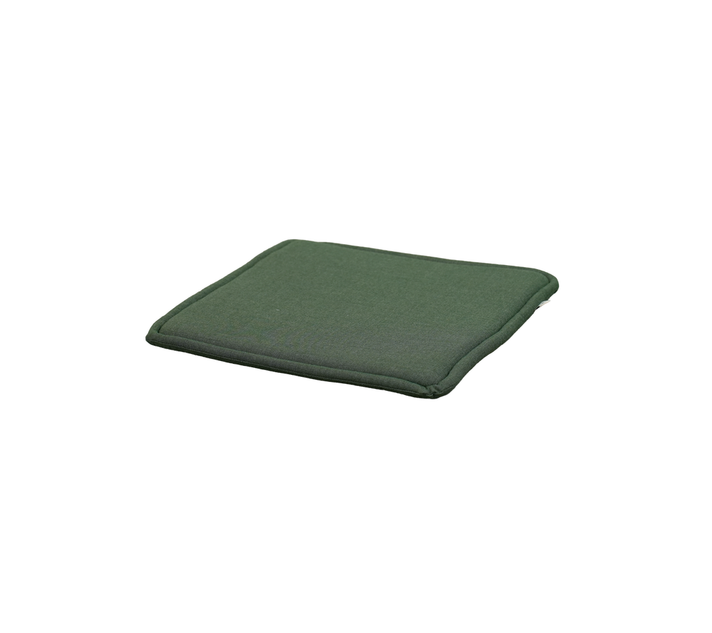 Lys grøn pude placeret på en flad overflade.