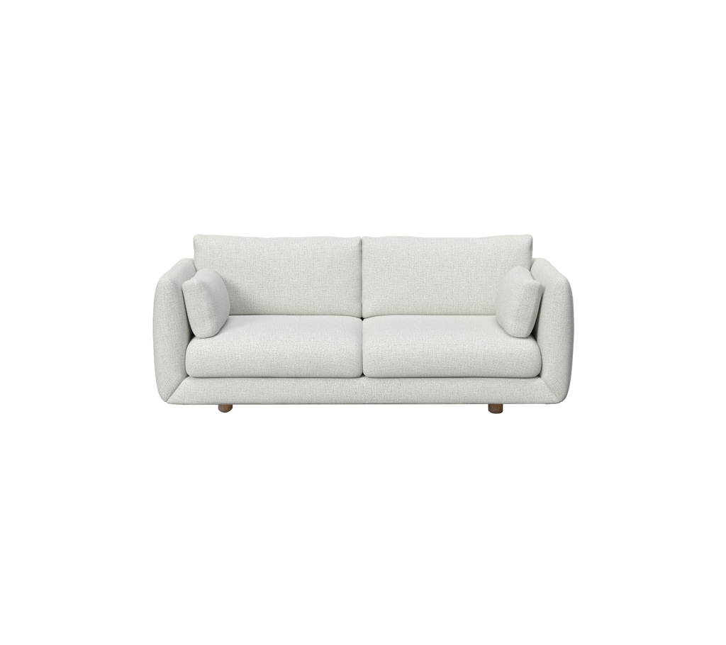 Lys grå sofa med runde puder i en moderne, minimalistisk stil.