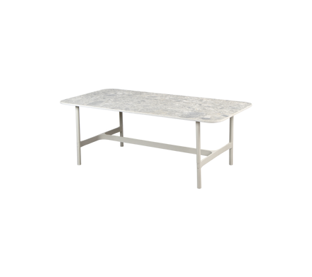 Et rektangulært bord med en tekstureret overflade og stabile ben, designet til forskellige indstillinger og aktiviteter.