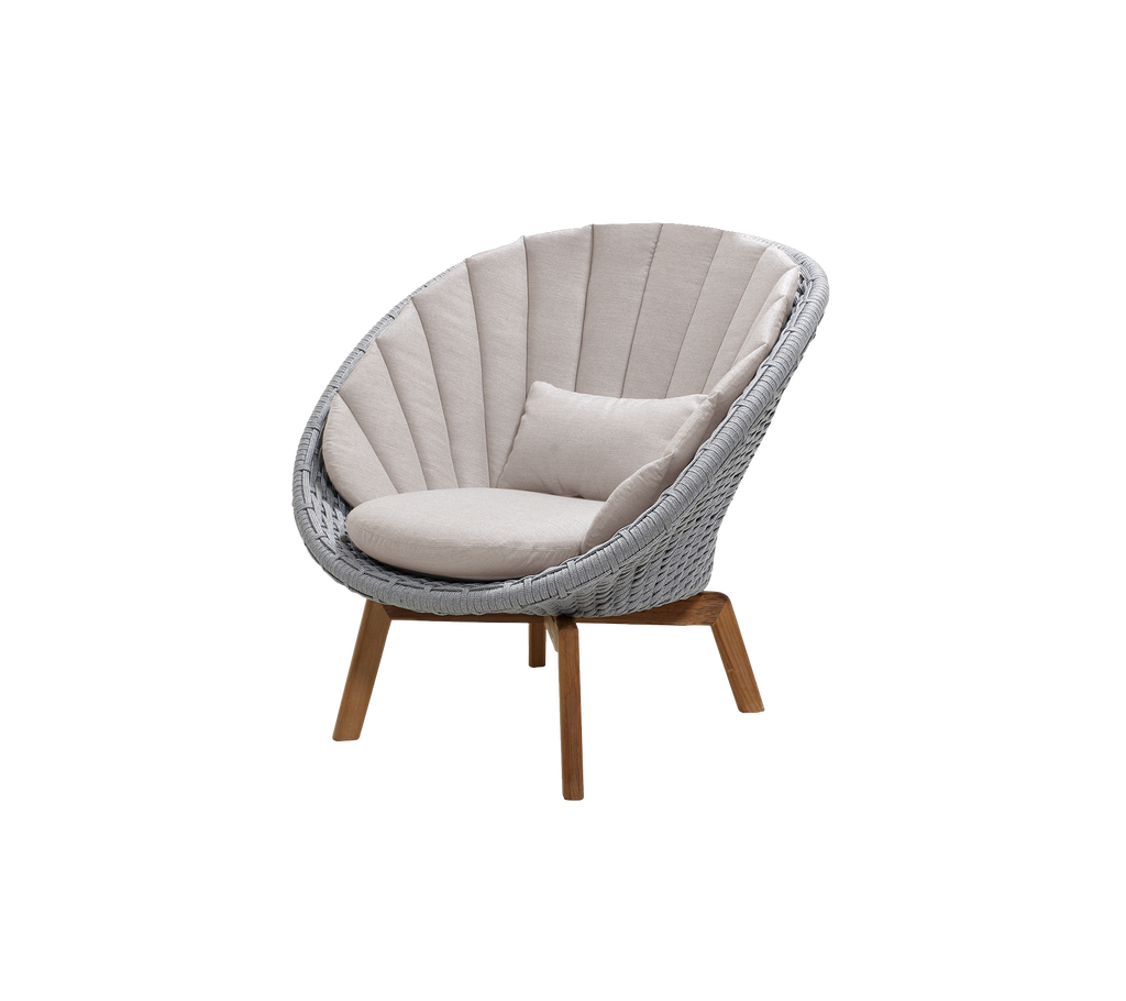 Moderne lys grå stol med sand pude i en loungeindstilling.