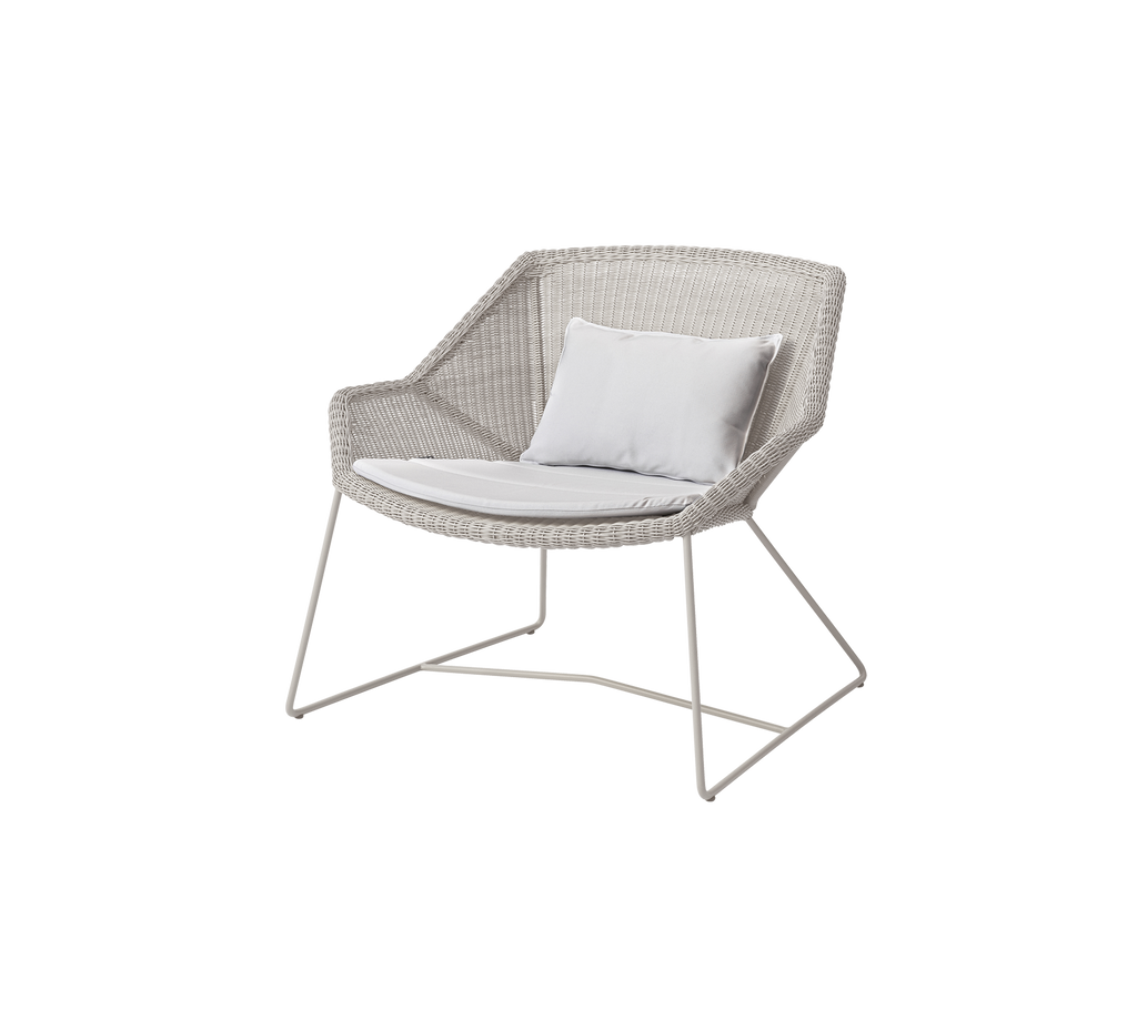 Moderne hvid stol med en hvid pude i en loungeindstilling.