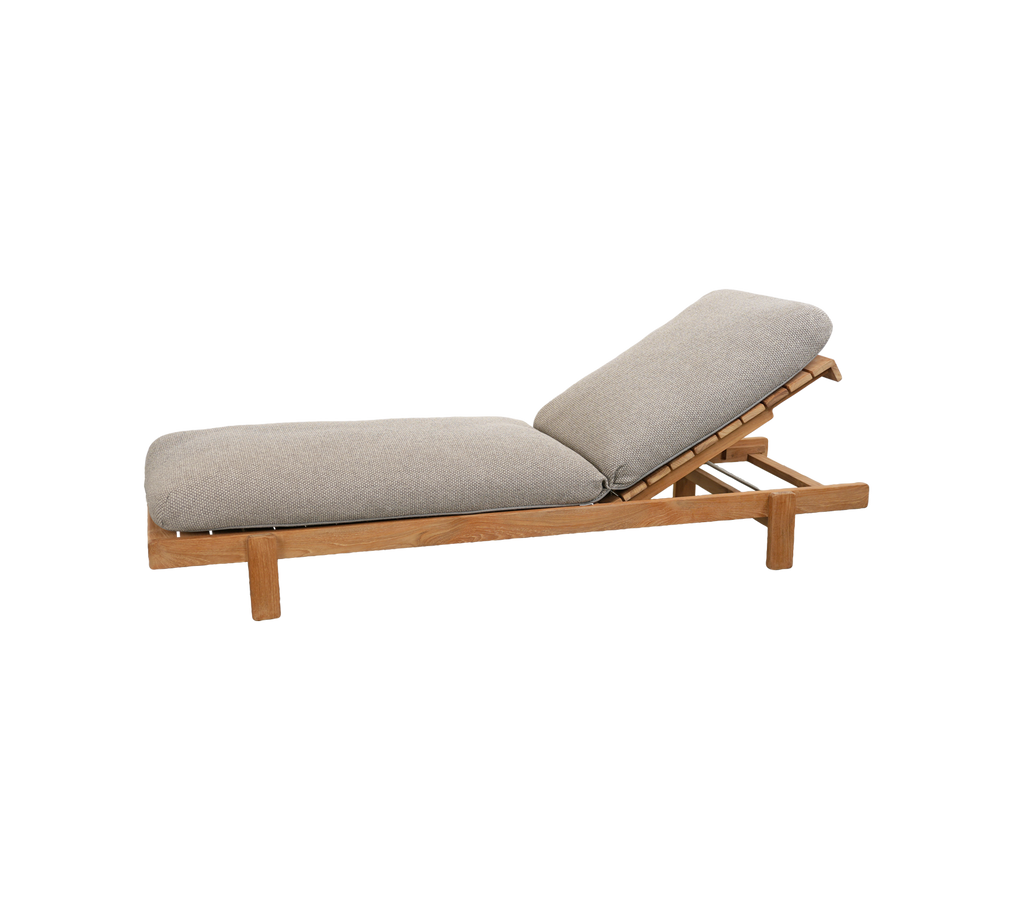 Lys brun loungestol med en grå pude og justerbart ryglæn.