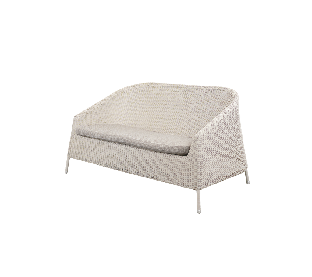 Moderne lounge sofa i sandfarve med en lysebrun pude.