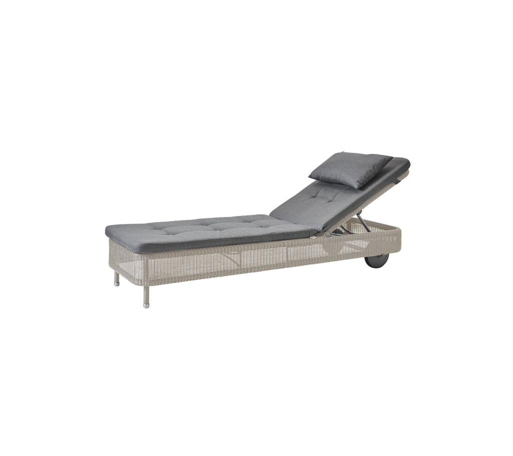 Moderne grå chaiselong med en sandfarvet pude.