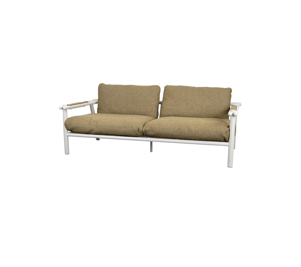 Moderne sofa med sandfarvede puder og en lys ramme.