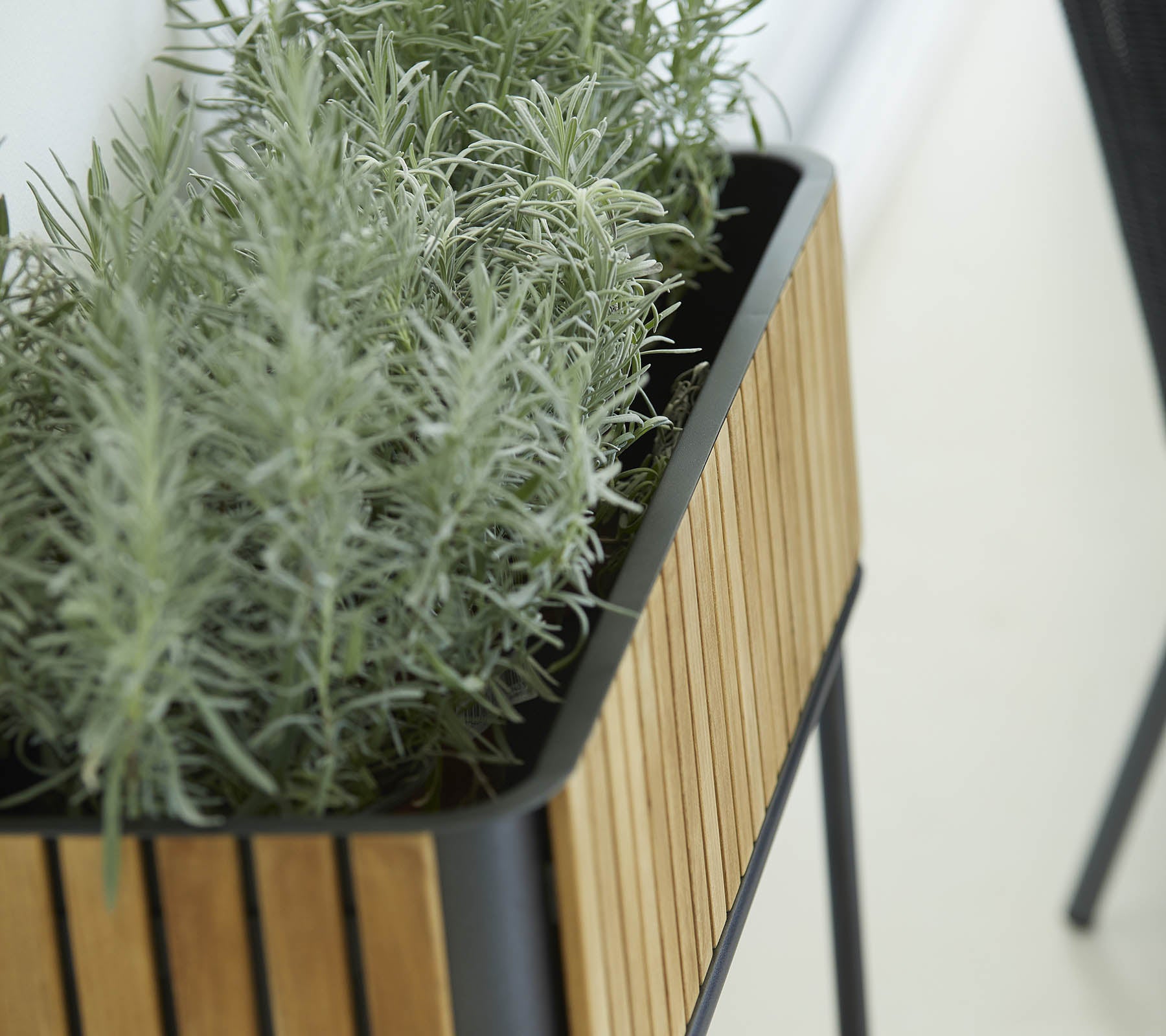 Planter med et elegant design, der har en ydre af træsliste og frodige grønne planter, som tilføjer et strejf af natur til omgivelserne.