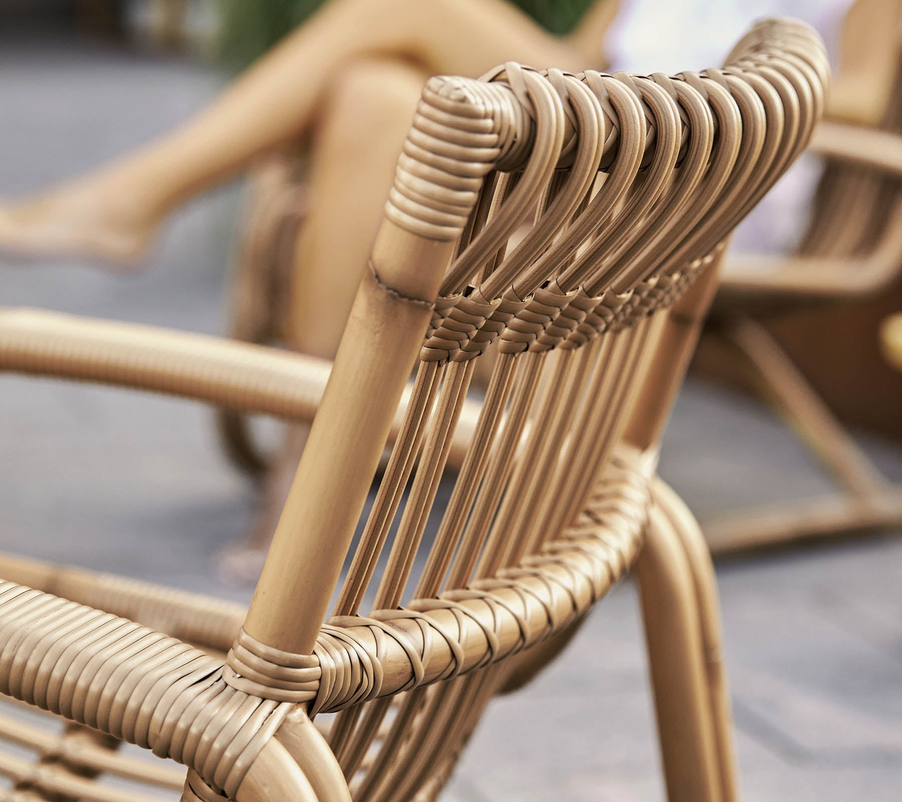 Detaljeret nærbillede af en stilfuld vævet stol med et moderne design, der viser detaljeret håndværk og naturlige materialer.
