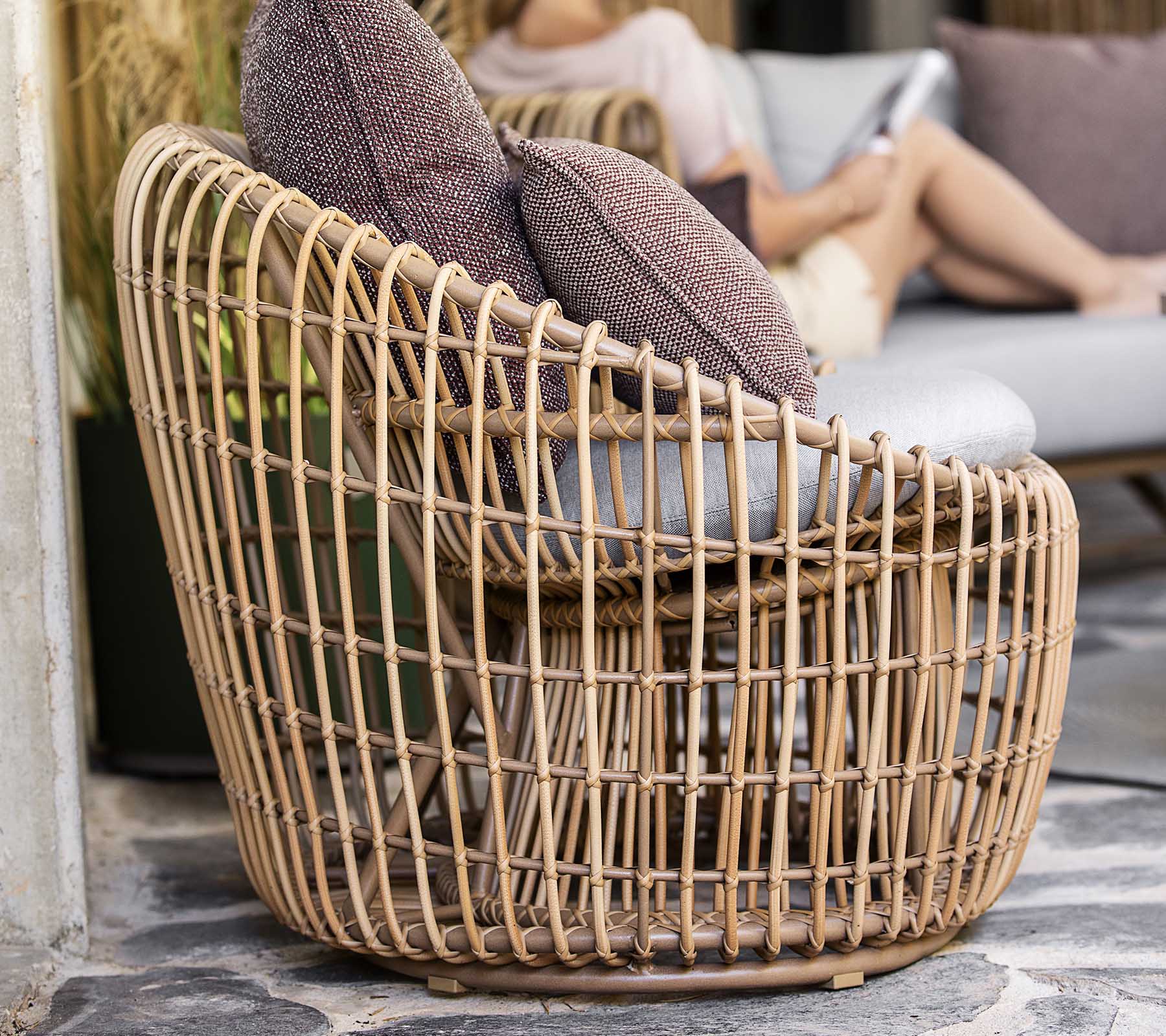 En stilfuld, vævet stol med et åbent design, der har to bløde puder for ekstra komfort. Perfekt til afslappet siddepladser.