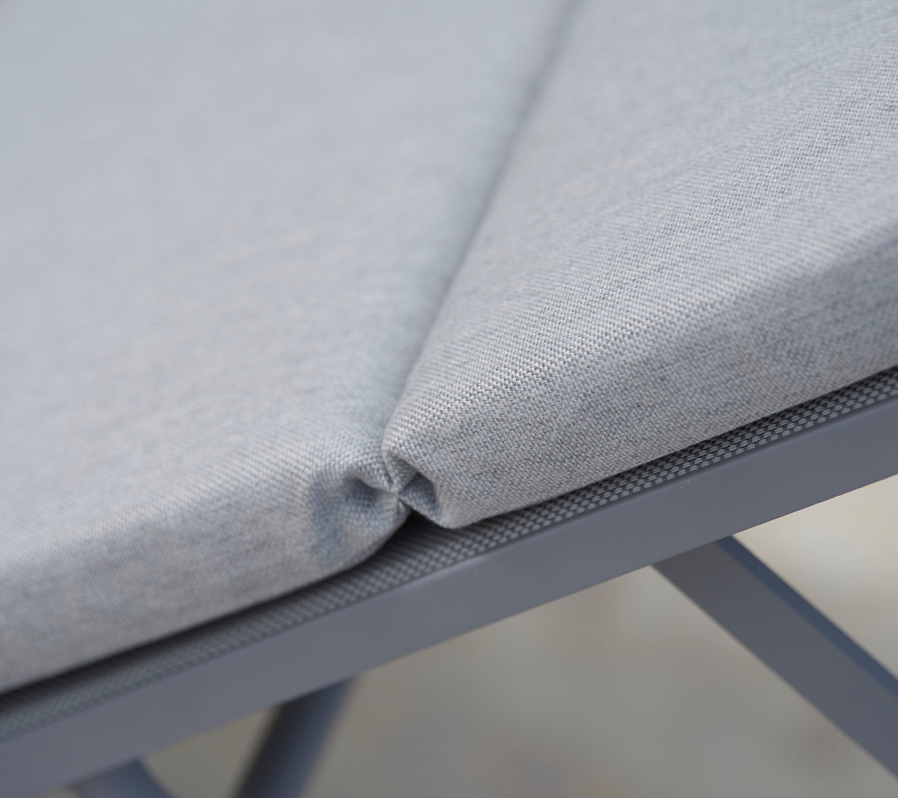 Grå polstret sidde-fabric med pæne syninger, der fremviser et sammenhængende design og en holdbar støtte struktur.