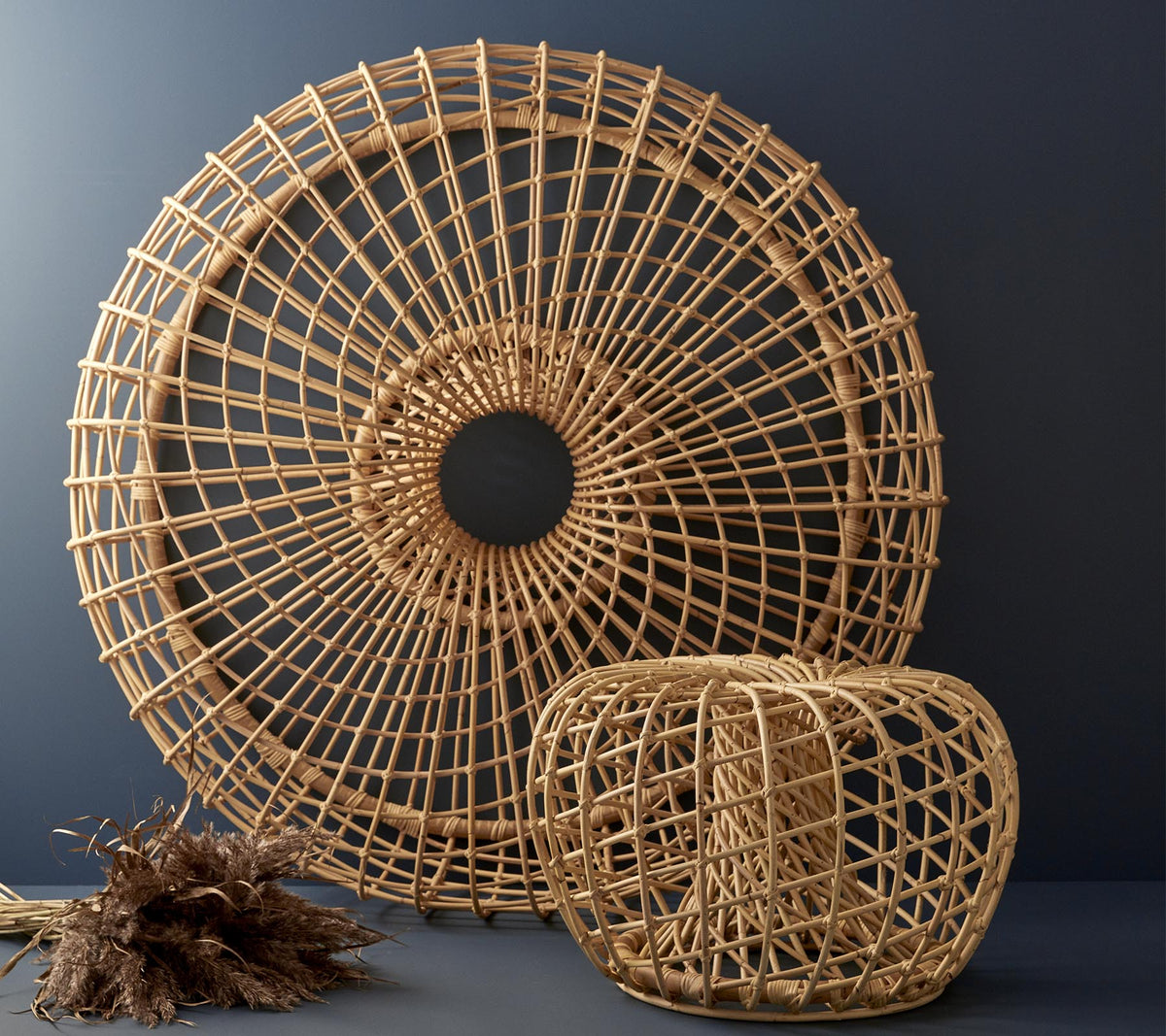 Vævede rattan dekorationselementer i en cirkulær form og et kubisk design, der viser indviklede mønstre og naturlige teksturer.