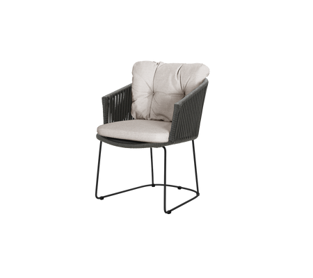 En komfortabel stol med en blød, polstret sæde og ryglænet, der har et stilfuldt vævet design og en robust ramme.
