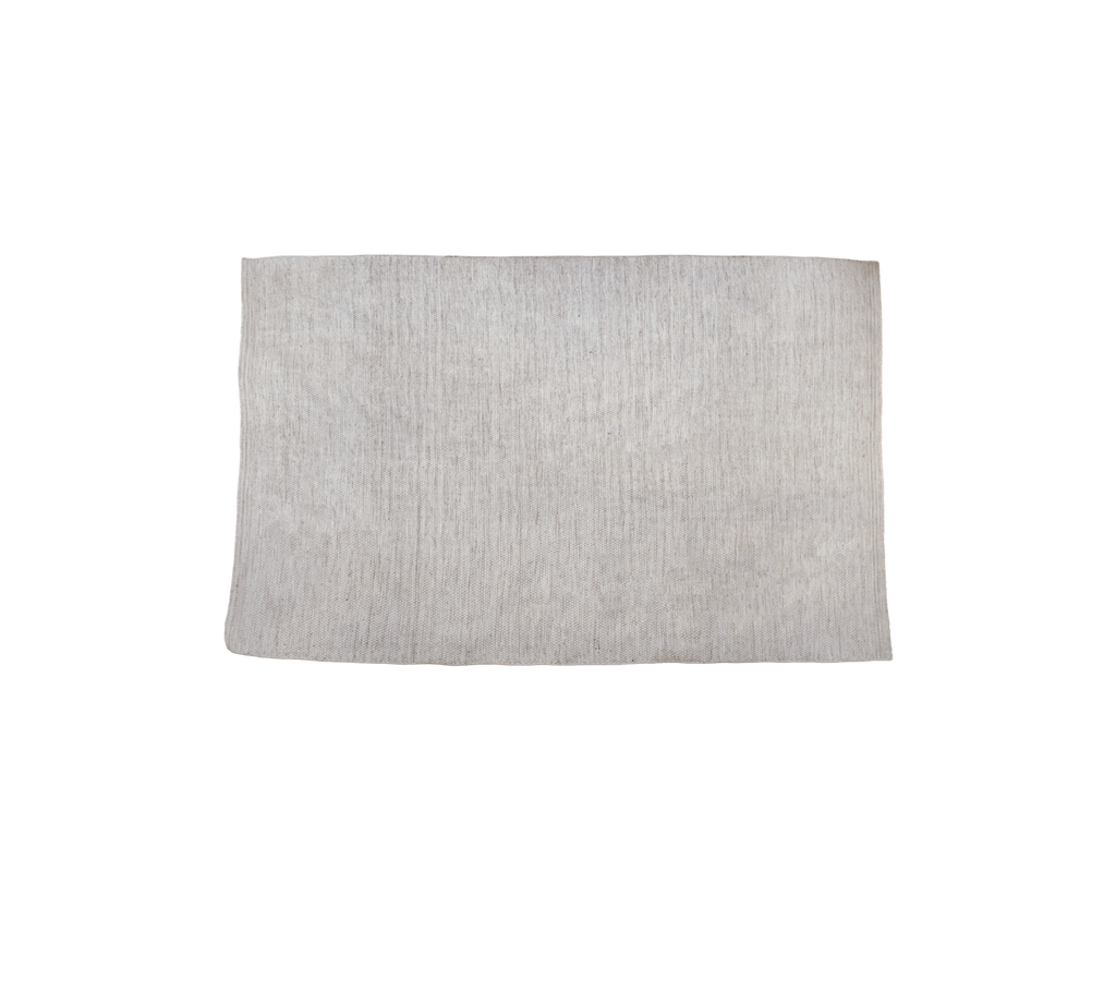 Multifarvet tæppe i en sandtone med tekstureret overflade.