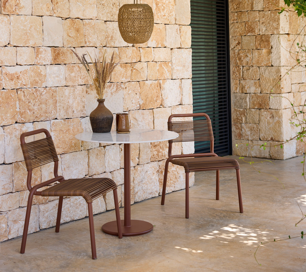 Moderne loungeopsætning med brune stole og et hvidt bord.