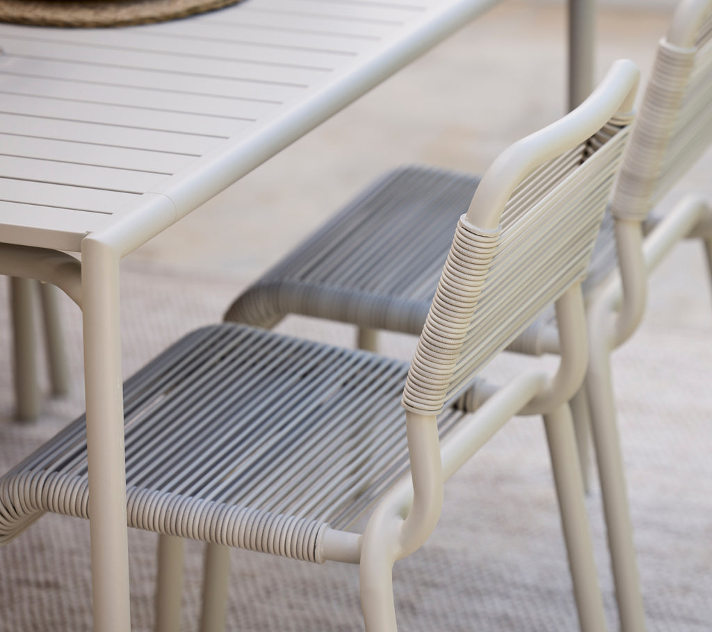 Moderne spisebord med hvid finish og grå stole.