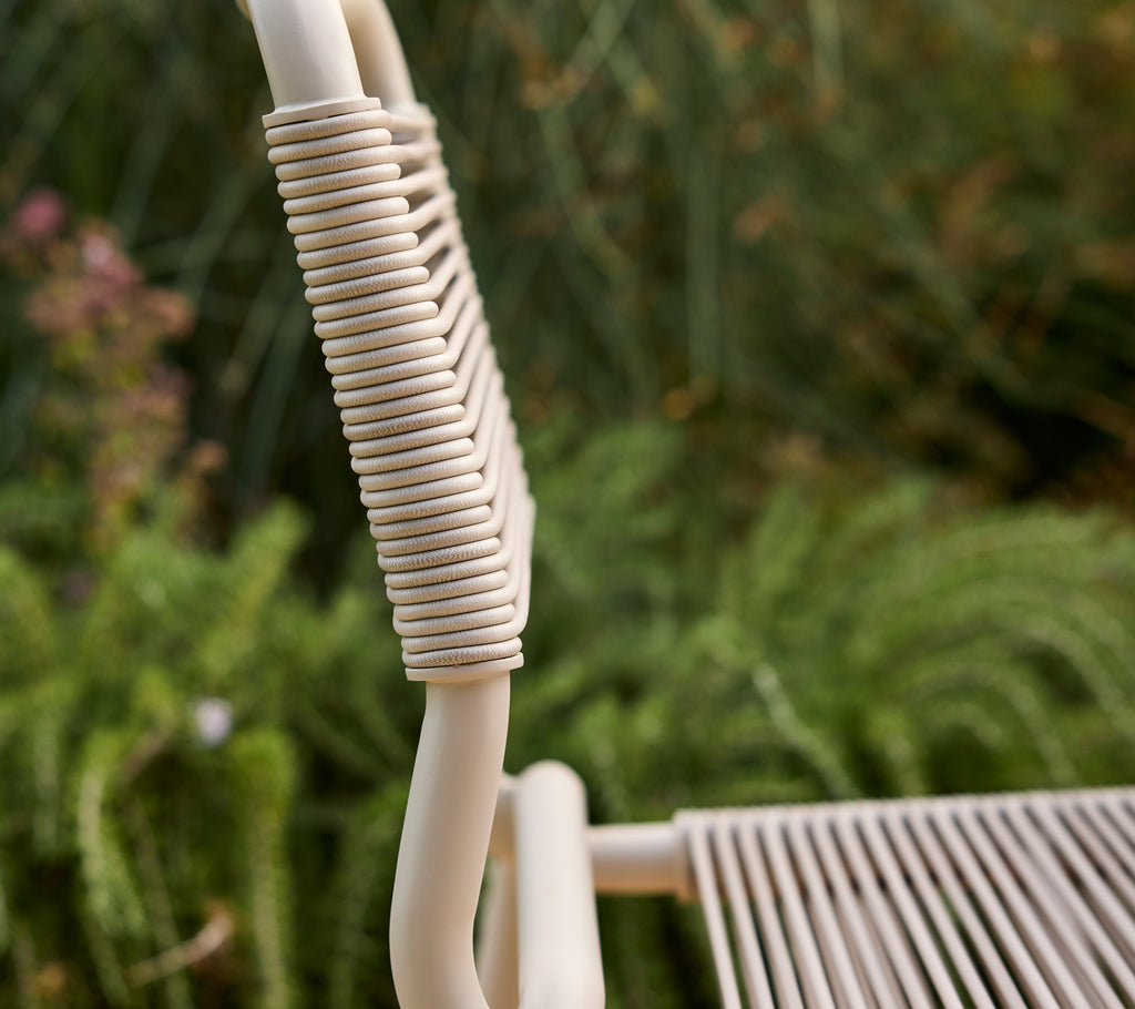 Beige stol delvist vist med en sløret grøn baggrund.