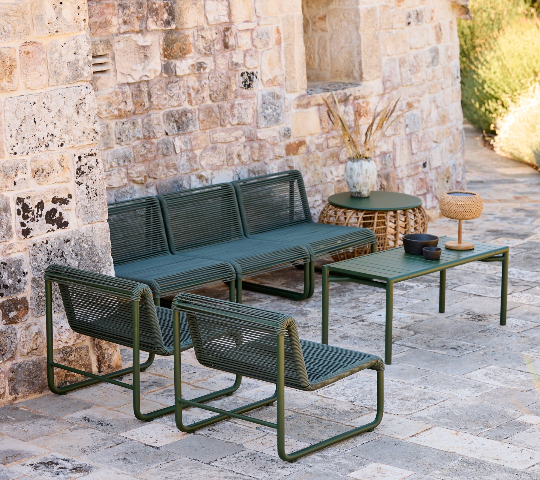 Moderne grøn sofa og stole med et matchende bord i en afslappet loungeindstilling.