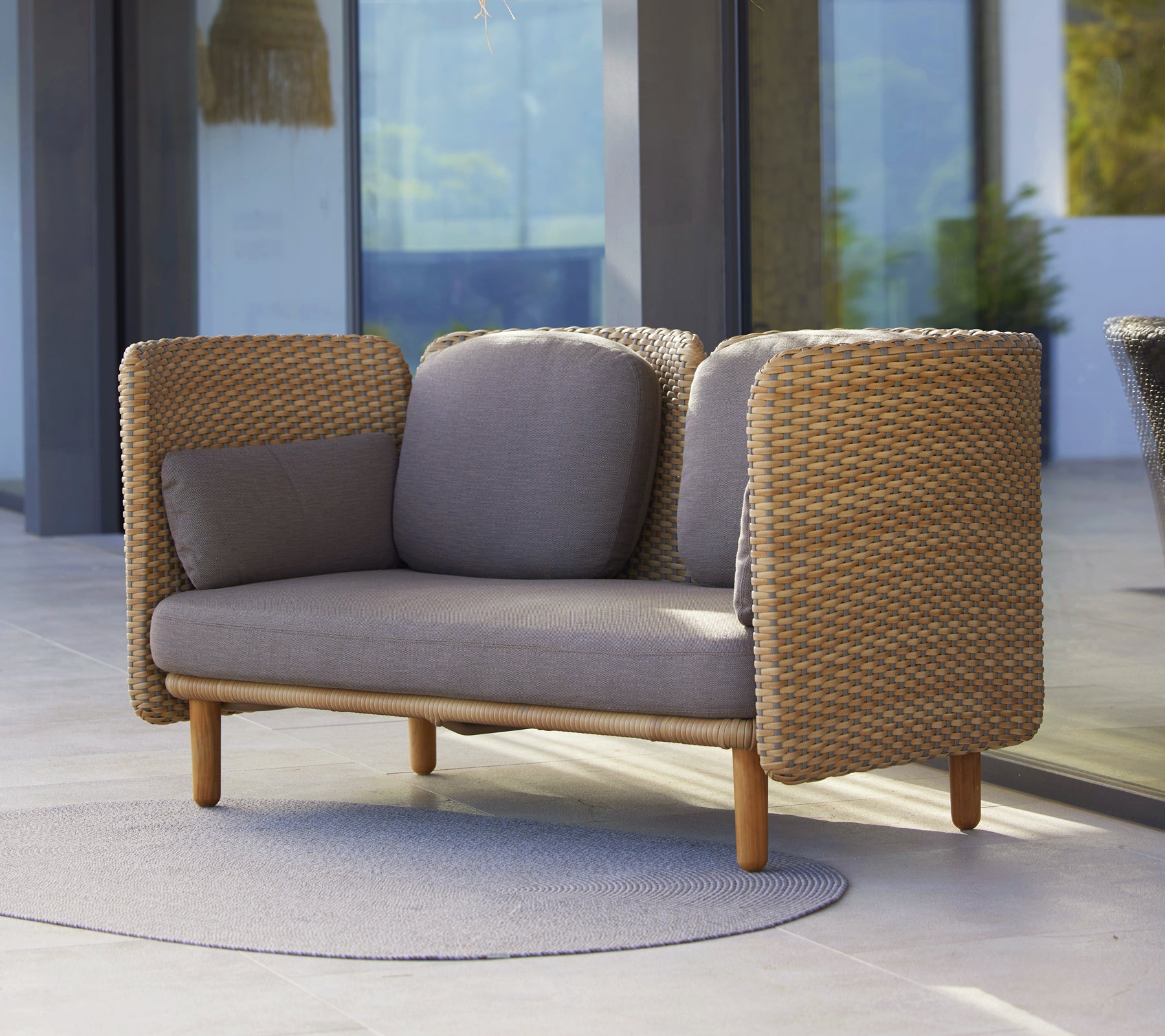 Arch 2-personers sofa med lav rygstøtte, vævede sider og neutrale puder, der kombinerer komfort med moderne design.