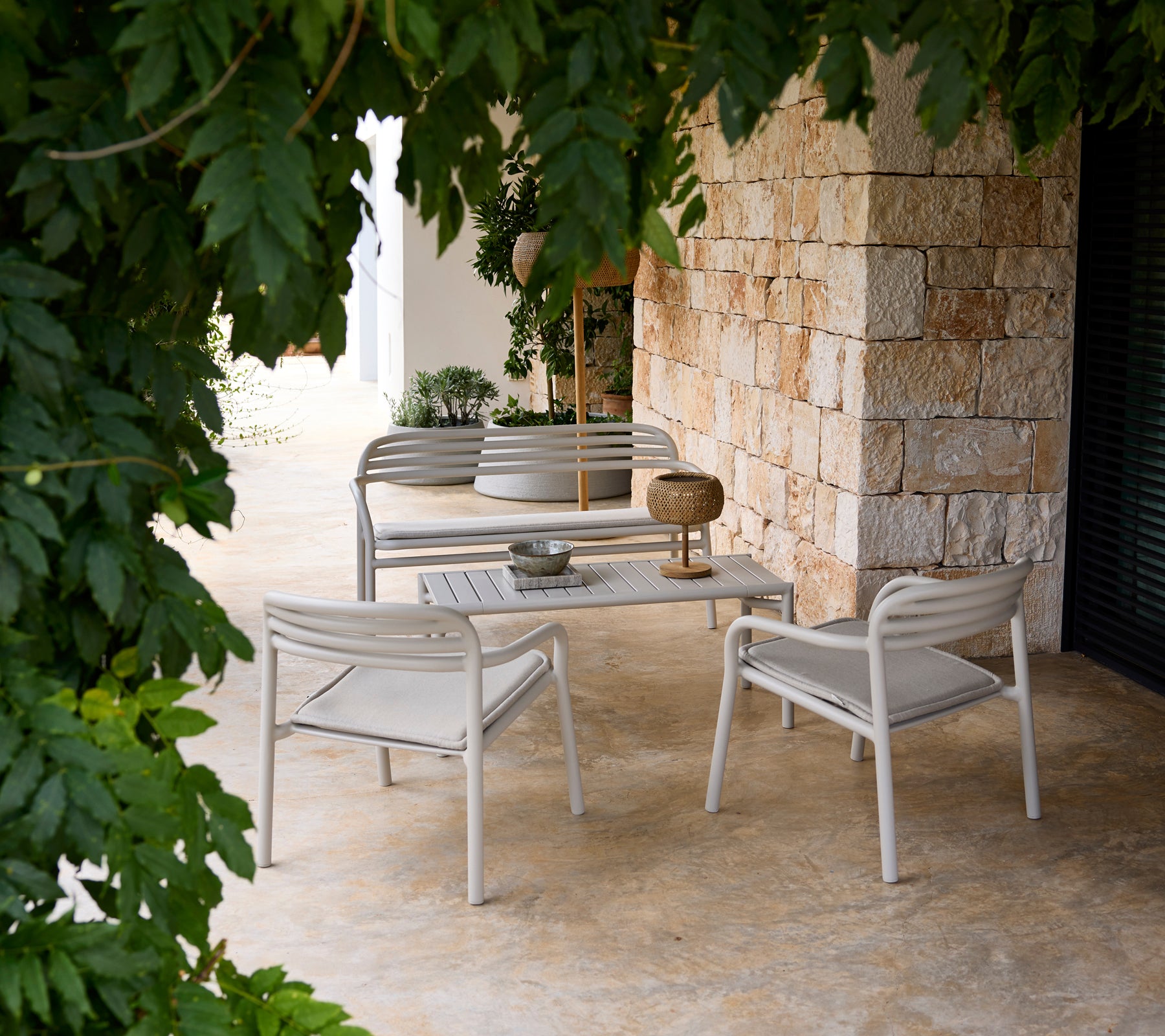 Grå sofa og stol med et hvidt bord i en moderne lounge-indretning.