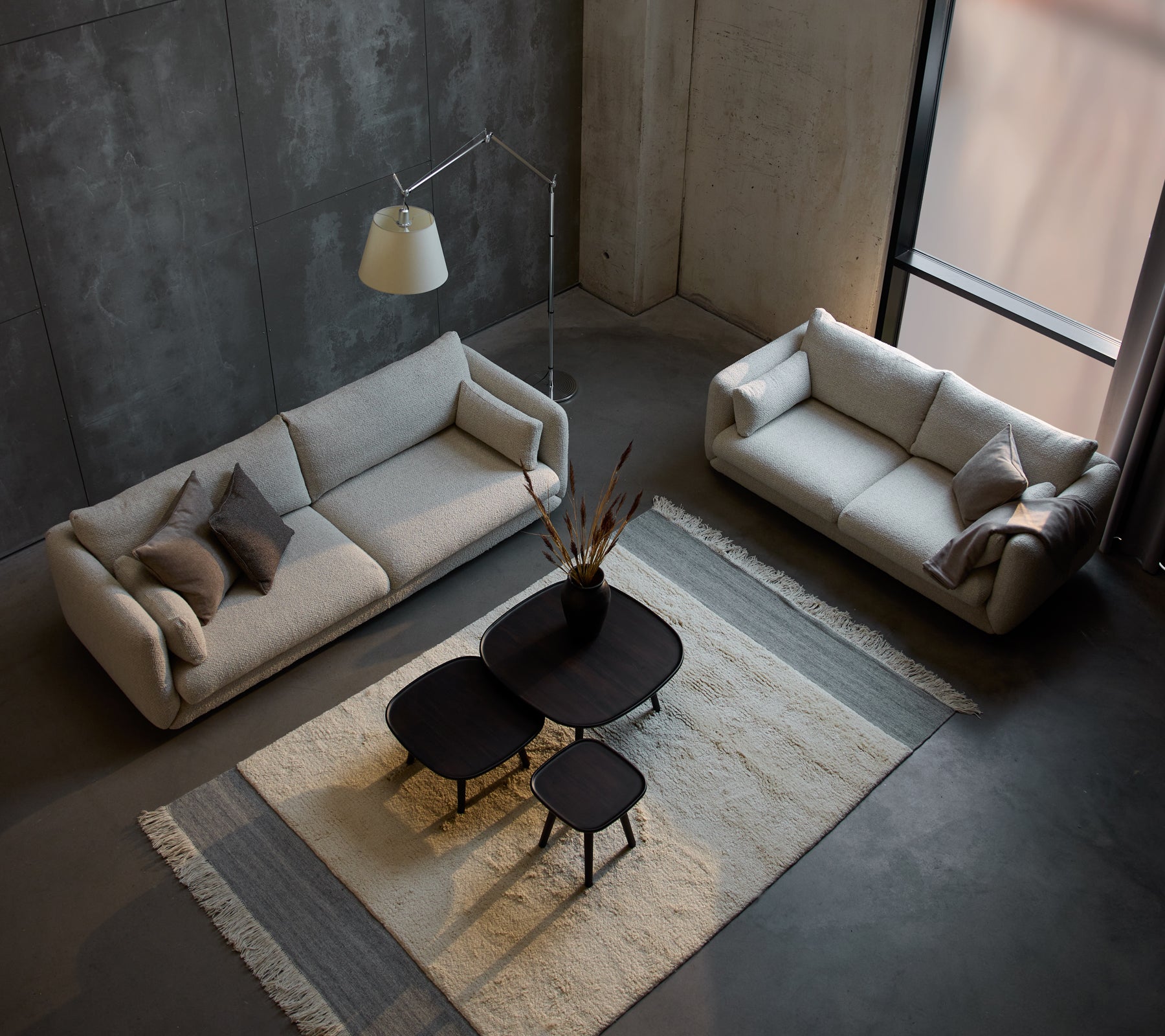 Et moderne opholdsområde med en Bloom 3-personers sofa, en mindre 3-personers sofa og stilfulde Pace kaffeborde på et struktureret tæppe.