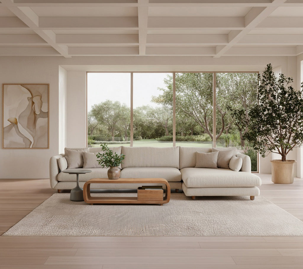 Moderne lounge med en beige sofa, et trækaffebord og en grøn plante.