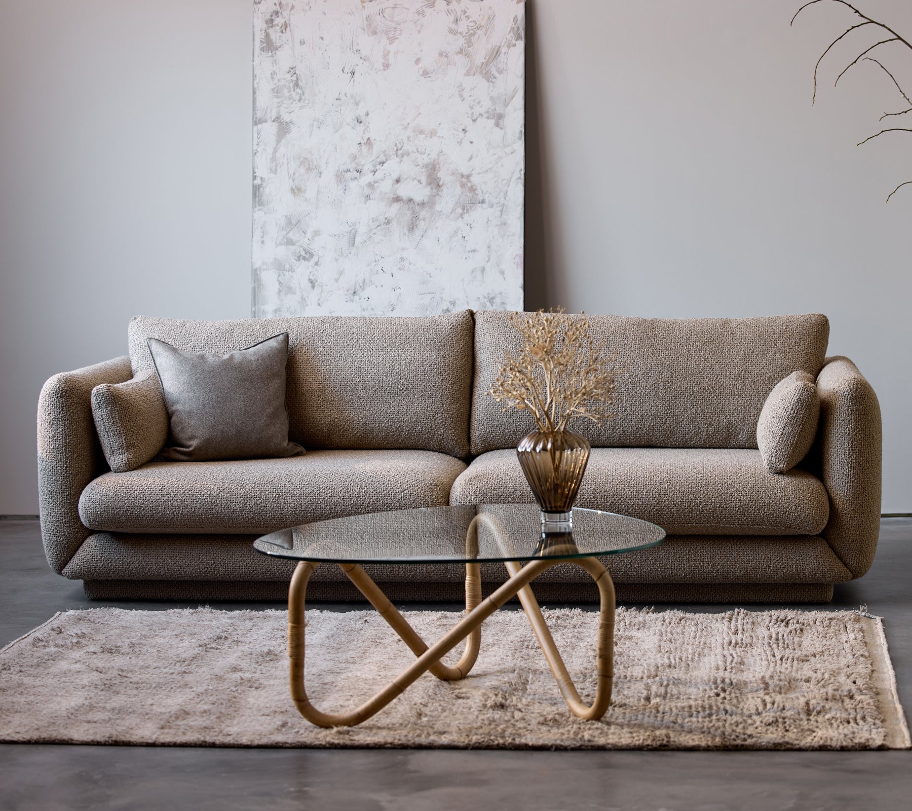 Bloom 3-personers sofa i taupe flair med en sokkel, parret med et Wave indendørs kaffebord og en dekorativ vase, på et blødt tæppe.