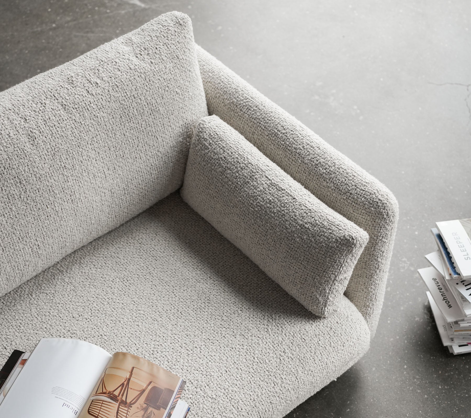 Stilfuld sofa med en tekstureret overflade, der har en blød armlæn og en behagelig pude, perfekt til at slappe af og læse.