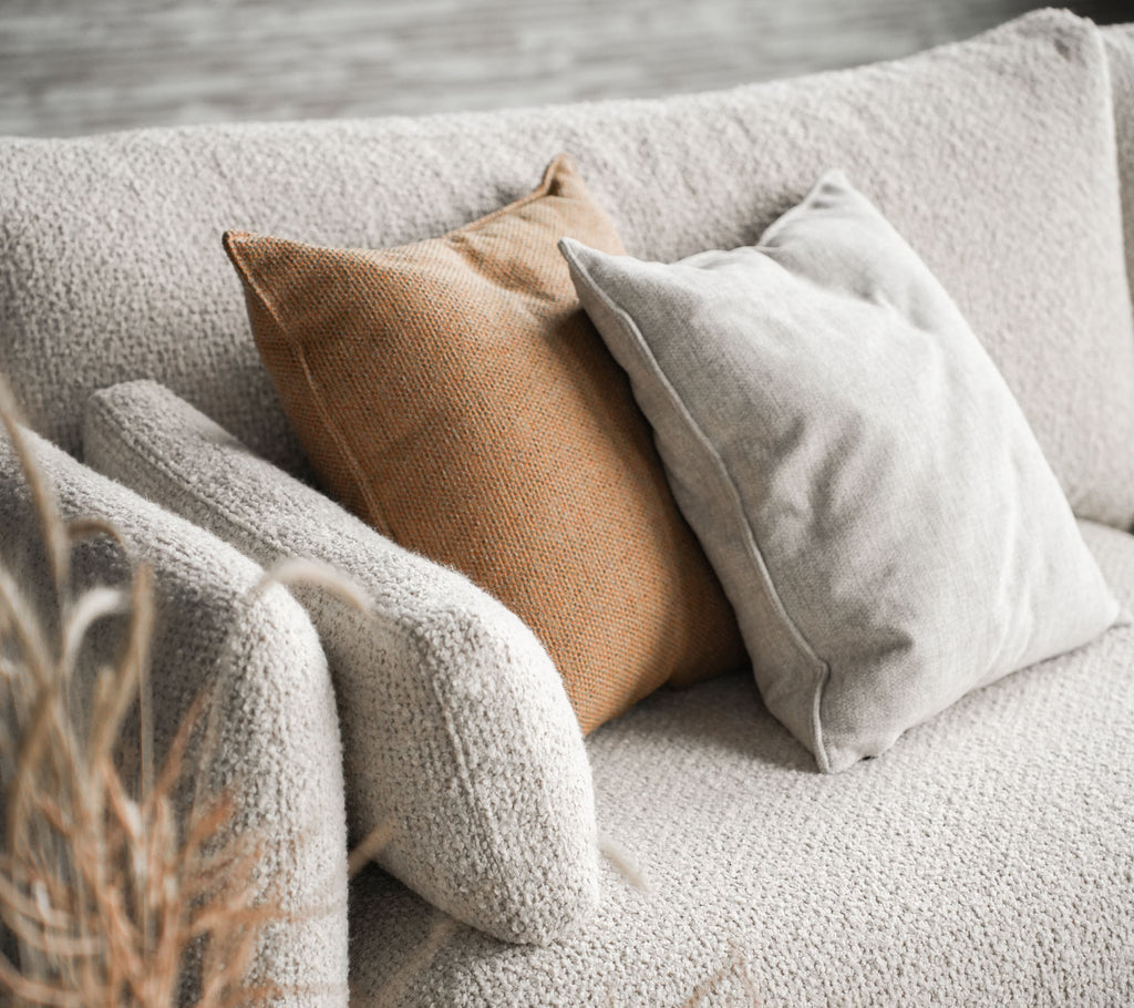 Hyggelig sofa med Bloom i sandfarve med to puder, en i beige og den anden i varm brun, som tilføjer et stilfuldt touch.