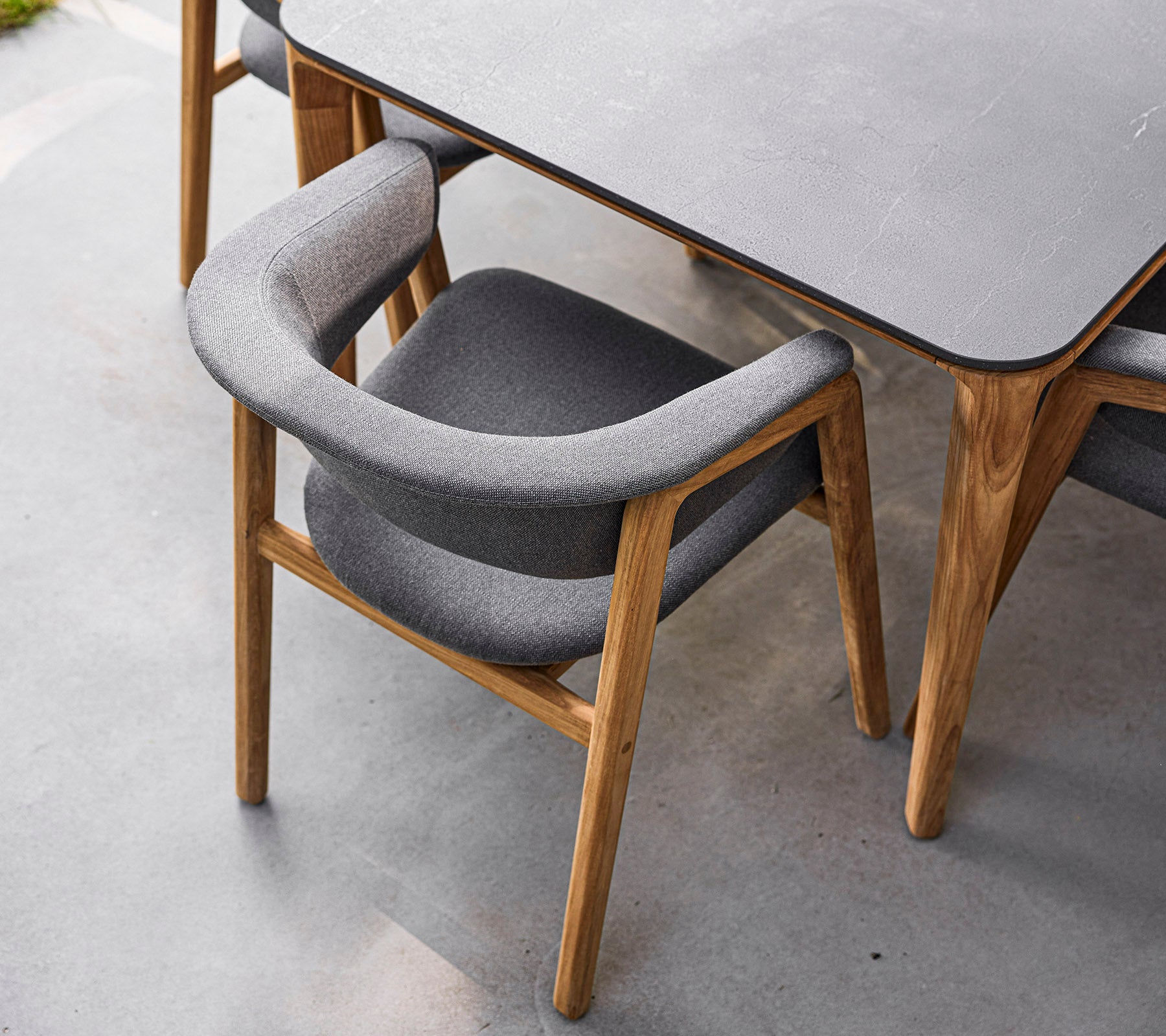 Stilfuld stol med træramme og blødt gråt polstring, designet til komfort og elegance. Perfekt til moderne spisestuer.