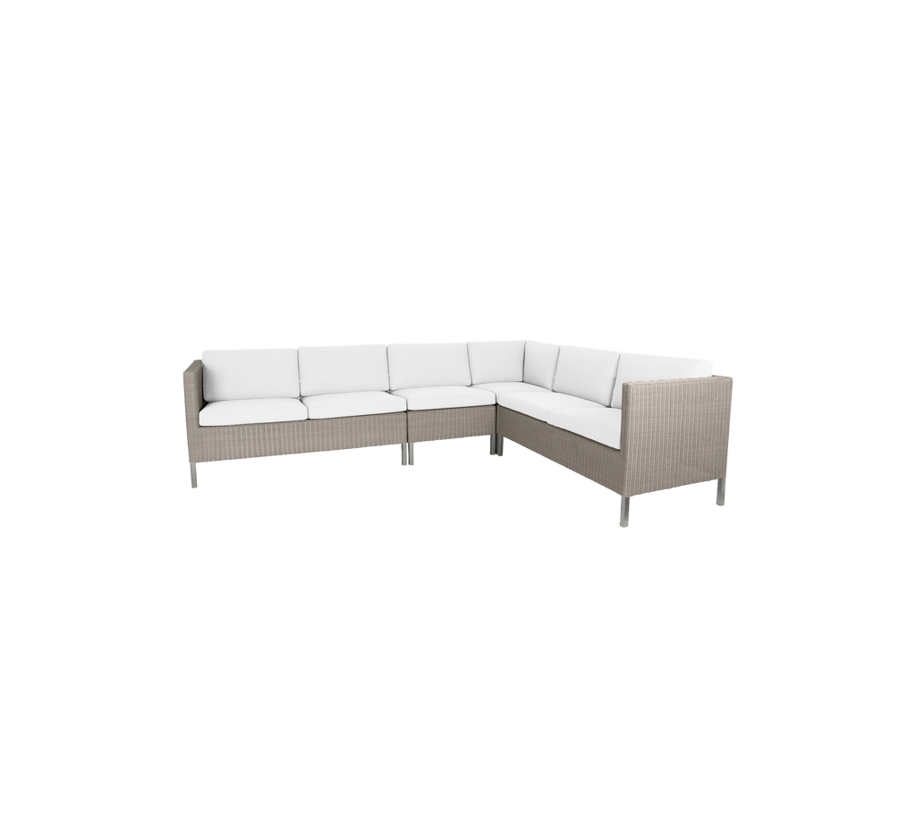 Stilfuld udendørs hjørnesofa med luksuriøse hvide puder og et moderne rattan design, perfekt til sammenkomster og afslapning.
