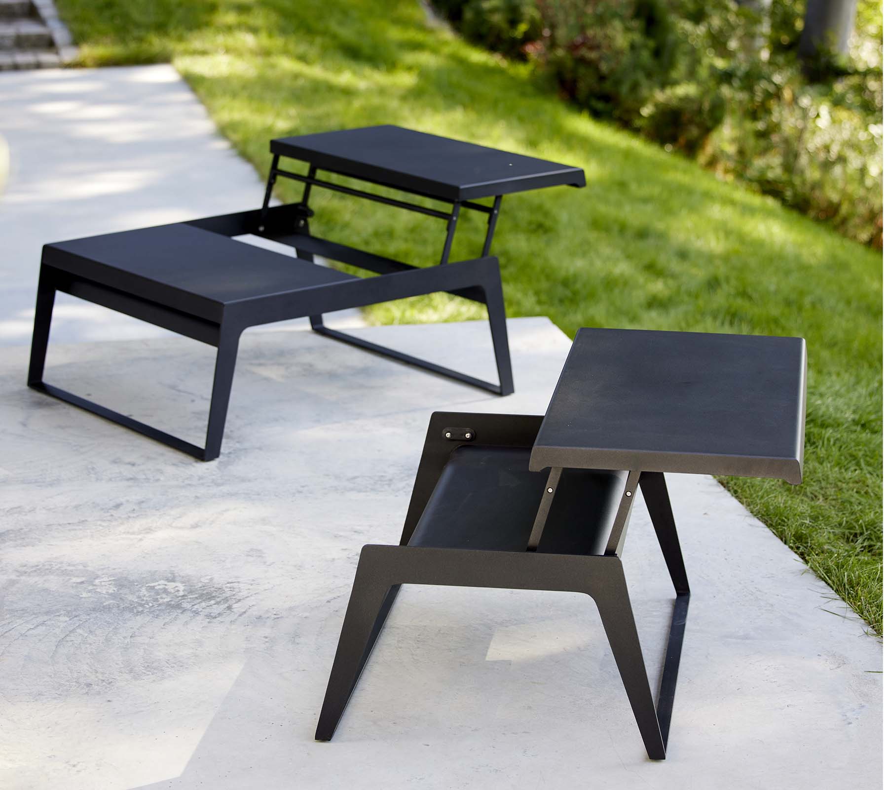 To moderne chill-out kaffeborde med slanke designs og minimalistiske sorte finish, der viser alsidighed i stil og funktionalitet.