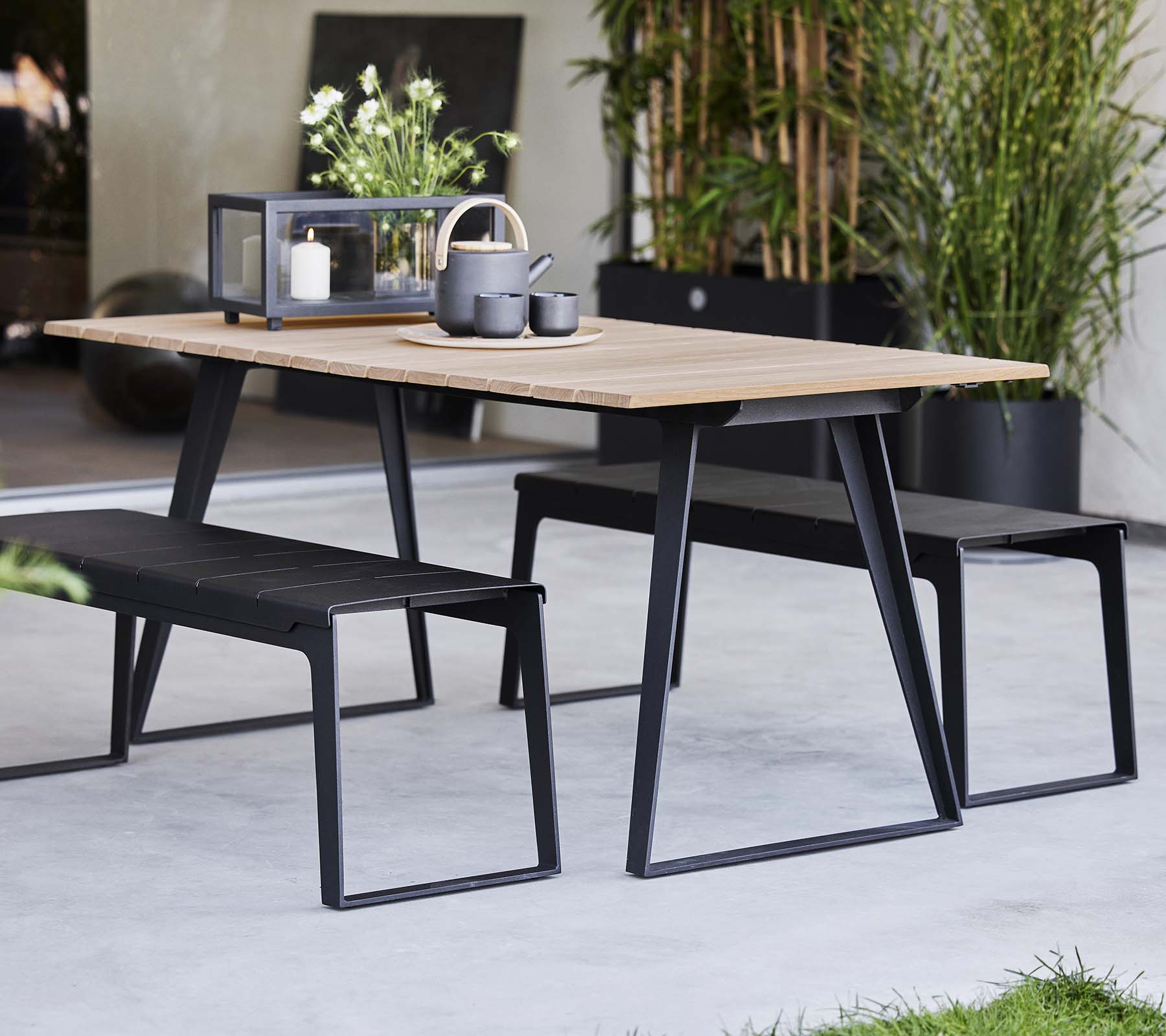 Stilet København bord parret med matchende bænke, der har et moderne design og minimalistiske dekorelementer.